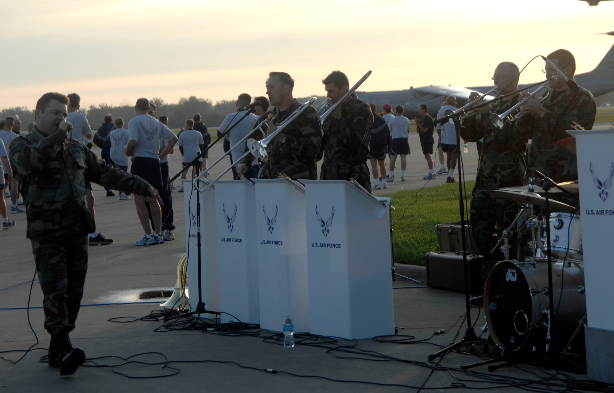 Participants in the Headquarters Air Mobility Command staff run cool down and listen to the Air Force Band of Mid America after they finished a mile and a half mile run Tuesday morning. About a hundred Airmen participated in the run on the Scott flightline and were treated to the sounds of Hot Brass, which recently returned from a deployment to Iraq. 