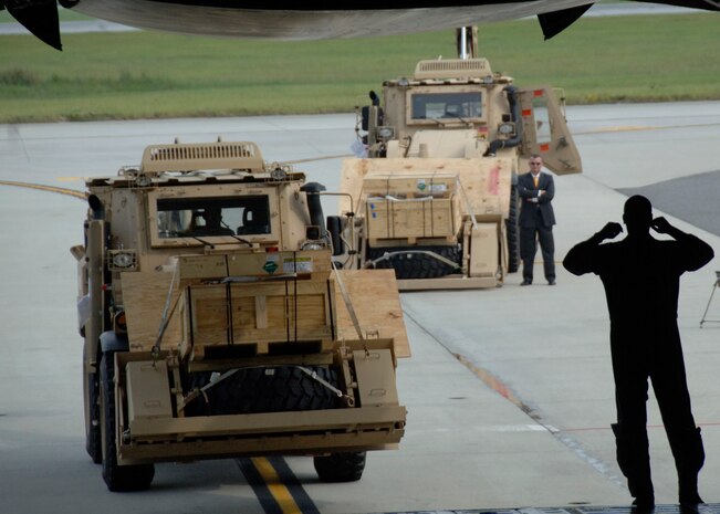 An Airman from the Memphis Air National Guard guides an HMEE into the back of a C-5 on the Charleston AFB flightline Sept. 29. Charleston AFB is the first Air Force base to help in aiding in transporting the vehicles to forward deployed Soldiers and contractors in hostile environments. The HMEE is a newly developed military construction vehicle capable of a wide range of mobility affording more protection for the operator than conventional excavators. (U.S. Air Force photo/Airman 1st Class Timothy Taylor)
