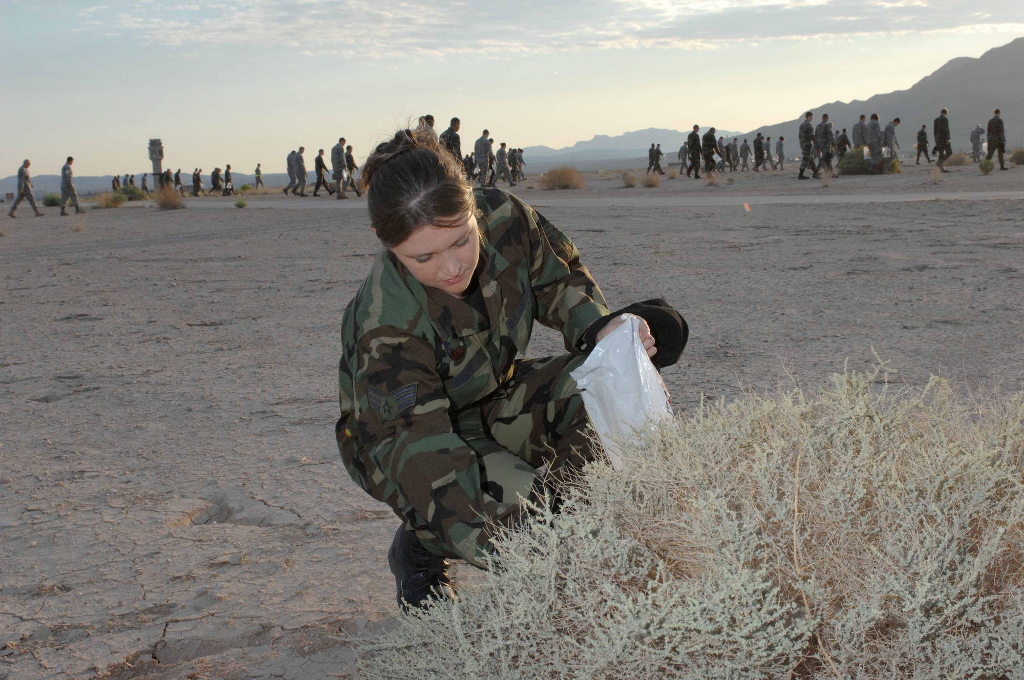 NELLIS AIR FORCE BASE, Nev. --  Senior Airman Aubree Hager, 57th Component Maintenance Squadron, aerospace ground equipment journeyman, collects debris near the base runway during the 57th Wing foreign object debris (FOD) walk on Sept. 30, 2008 Nellis Air Force Base, Nev. FOD walks are conducted on a regular basis to prevent debris from potentially damaging Air Force aircraft assets. (U.S. Air Force Photo by/Senior Airman Larry E. Reid Jr.)