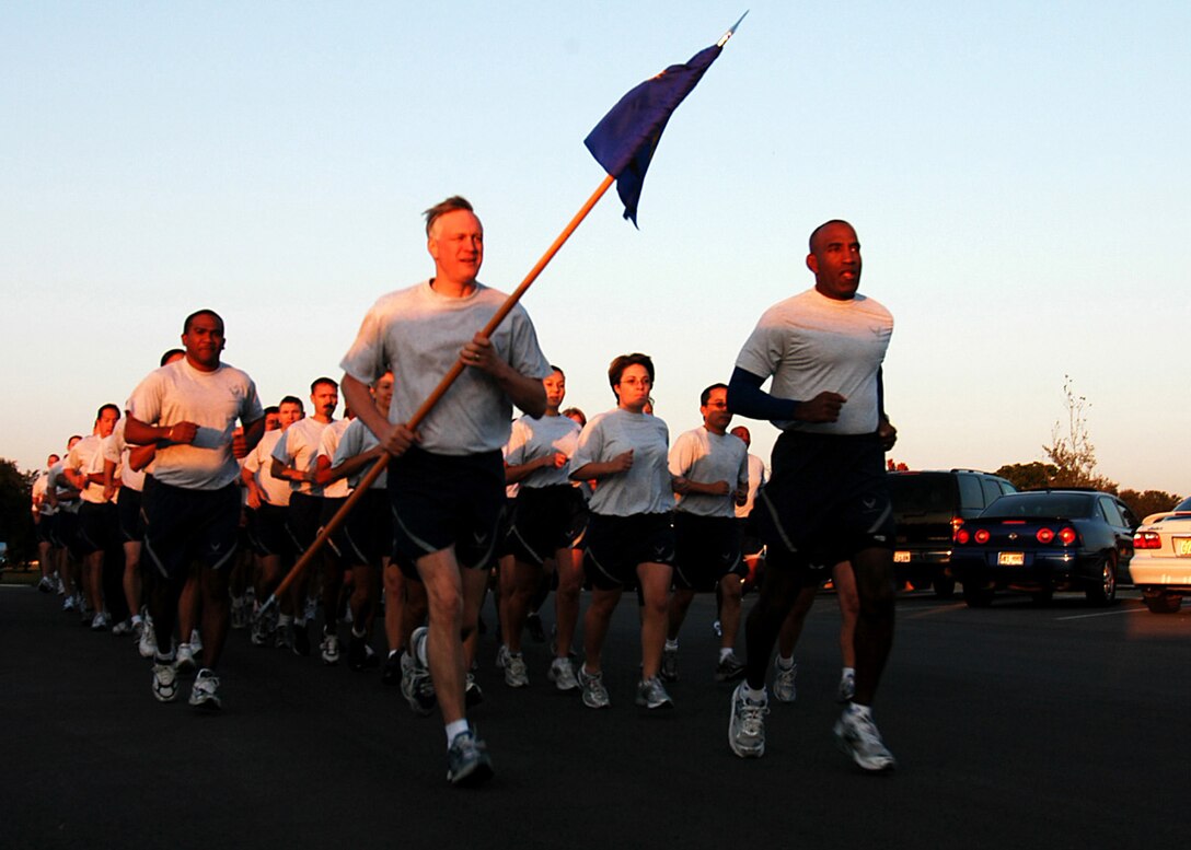 Air Force Recruiting Service headquarters Airmen usher in the new fiscal year with the organization’s first formation run Oct. 1 around Randolph Air Force Base’s Airman’s Heritage Park. Command Chief Master Sgt. Vance Clarke carries the unit guidon and Commander Brig. Gen. A.J. Stewart, front right, sets the pace. The event initiated the first of three monthly AFRS physical fitness runs to take place each annual quarter. AFRS members do a 1.5 mile formation run the first month of the quarter, a timed 1.5 mile run the second month and a 1.5 mile fun run and walk with family members the third month. The purpose of the unit events is to enhance Airman fitness and camaraderie.  (U.S. Air Force photo/Staff Sgt. Jennifer Lindsey)