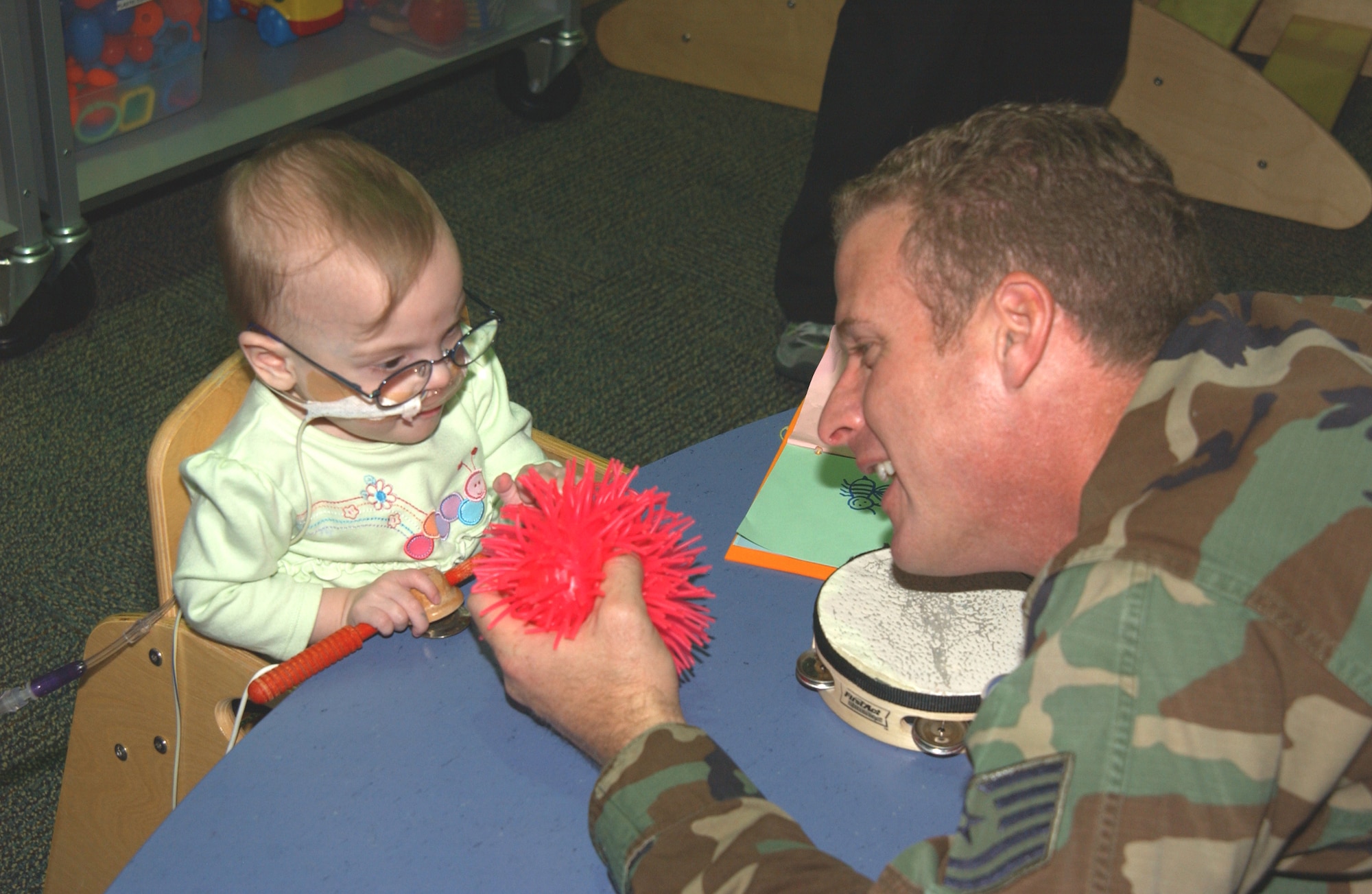 SCOTT AIR FORCE BASE, Ill. --Tech. Sgt. David French, 375th Communications Squadron client support NCOIC, entertains Delilah, a Ranken Jordan-pediatrics specialty hospital patient, on an Airmen for Children visit. Sergeant French has volunteered a couple of times to spend an hour with children staying at Ranken Jordan. Both Sergeant French and Staff Sergeant Hicks have built good relationships with many of the children in the hospital. Many of the children know them by name and speak to them while they are in the hospital. 
(U.S. Air Force photo/Airman 1st Class Amber Kelly-Woodward)
