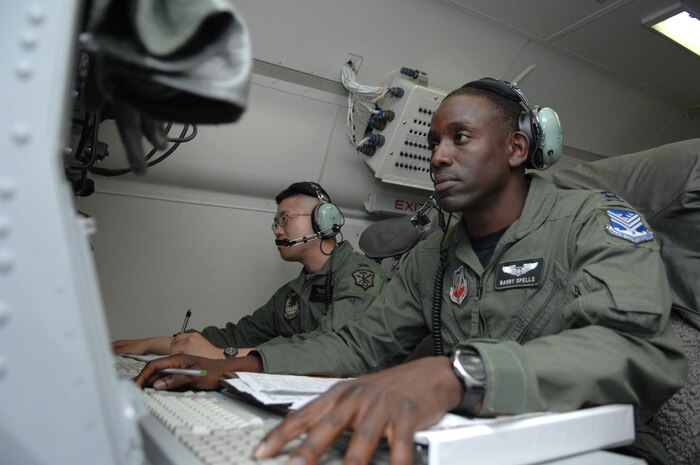 NELLIS AIR FORCE BASE, Nev. -- Air Force Capt. Barry Spells (foreground), E-8C Joint Surveillance Target Attack Radar System senior director and Army Capt. Steven Kobayashi, deputy mission crew commander, both assigned to the 116th Air Control Wing, Robins Air Force Base, Ga., monitor data being transferred to ground forces during a flying mission from Nellis AFB in support of Green Flag West on Sept. 25, 2008. The JSTARS provides long-range, air-to-ground surveillance designed to locate, classify and track ground targets for the Army and Marine Corps. (U.S. Air Force Photo/Senior Airman Larry E. Reid Jr.)