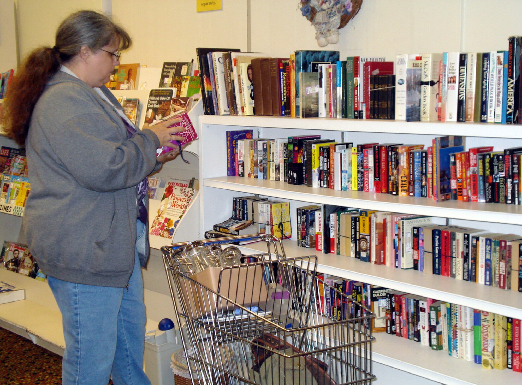Patricia Stacy, a frequent shopper at the Thrift Shop, checks out books Oct. 1. The Thrift Shop’s annual Fall Yard Sale will be held Oct. 4, 10 a.m. to 2 p.m., outside the store. (U.S. Air Force photo/Airman 1st Class Bekah Phy)