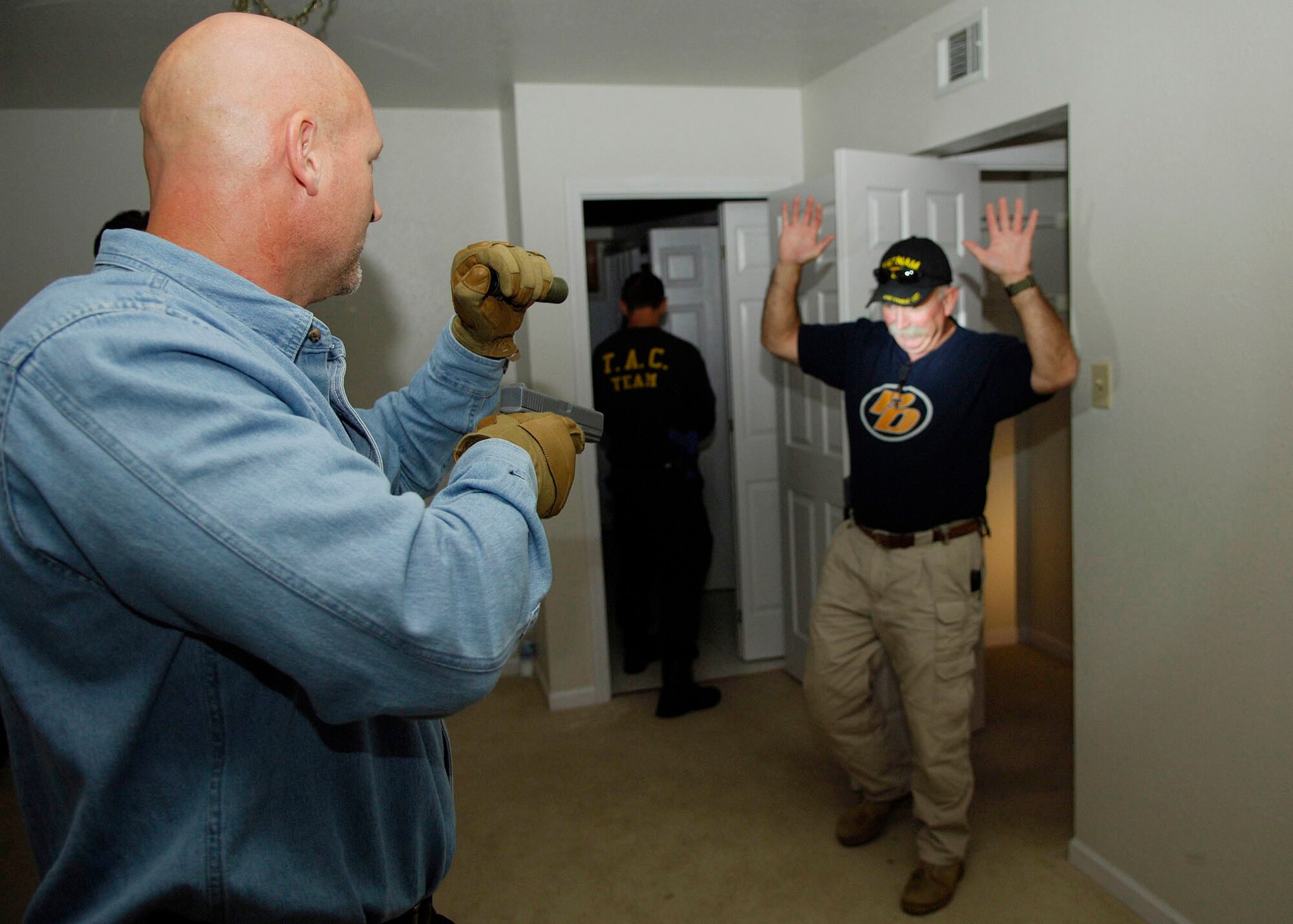 SCOTT AIR FORCE BASE, Ill. --Chris Vereeke, Defense Criminal Investigative Service, gives John Andrews, U.S. Marshals Task Force, orders during a practice search of a home Sept. 24 at Scott. Mr. Vereeke and Mr. Andrews were participating in a joint law enforcement training session in which they learned and perfected new and safer ways to efficiently search and clear a home. 
(U.S. Air Force photo/Airman 1st Class Wesley Farnsworth)
