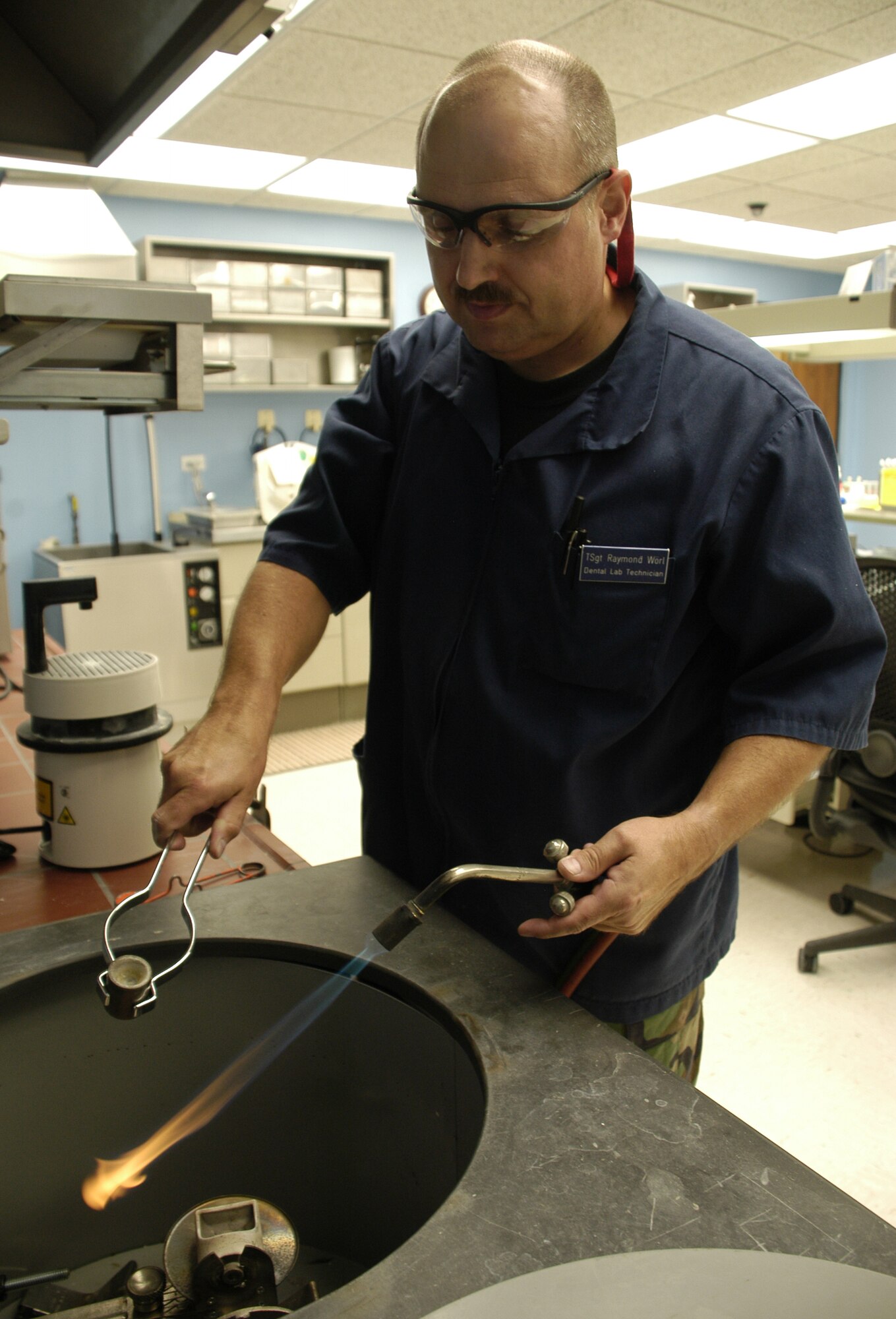 DOVER AIR FORCE BASE, Del. – Tech. Sgt. Raymond Worl, 436th Dental Squadron NCO in-charge of the dental laboratory, uses a propane gas and oxygen torch to melt the metal which will be cast into the tooth mold. This will create either a gold or silver crown, or the metal substructure needed to apply porcelain for a porcelain-fused metal crown. (U.S. Air Force photo/ Airman 1st Class Shen-Chia Chu)