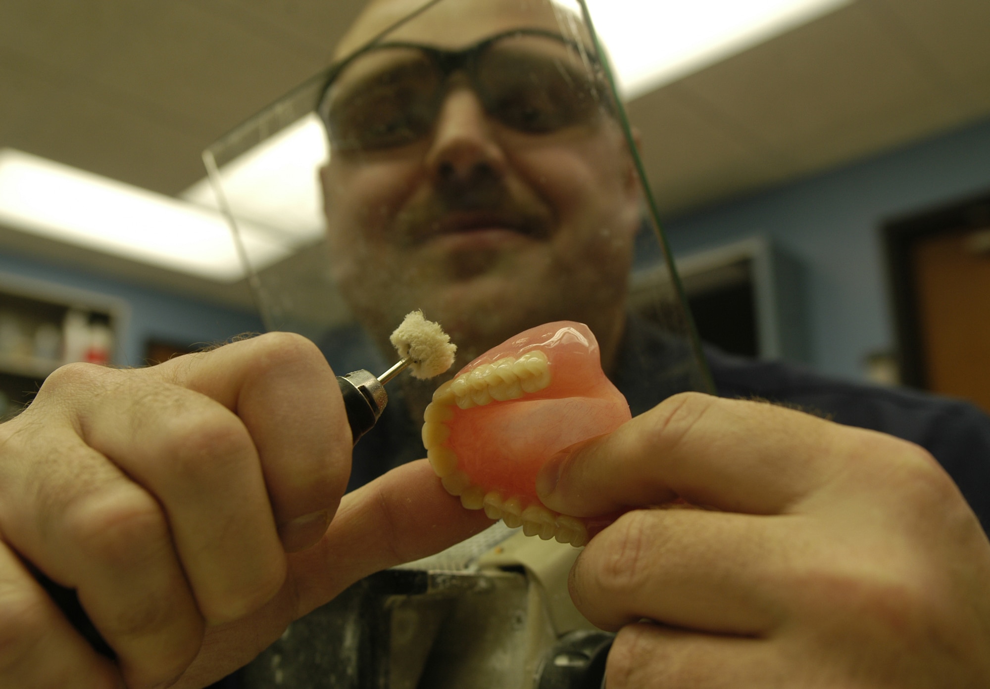 DOVER AIR FORCE BASE, Del. – Tech. Sgt. Raymond Worl, 436th Dental Squadron NCO in-charge of the dental laboratory, uses a rag wheel to smooth and polish a complete denture. All dental appliances are smoothed to prevent rough areas or pits that could trap food particles for denture-wearing patients. (U.S. Air Force photo/ Airman 1st Class Shen-Chia Chu)