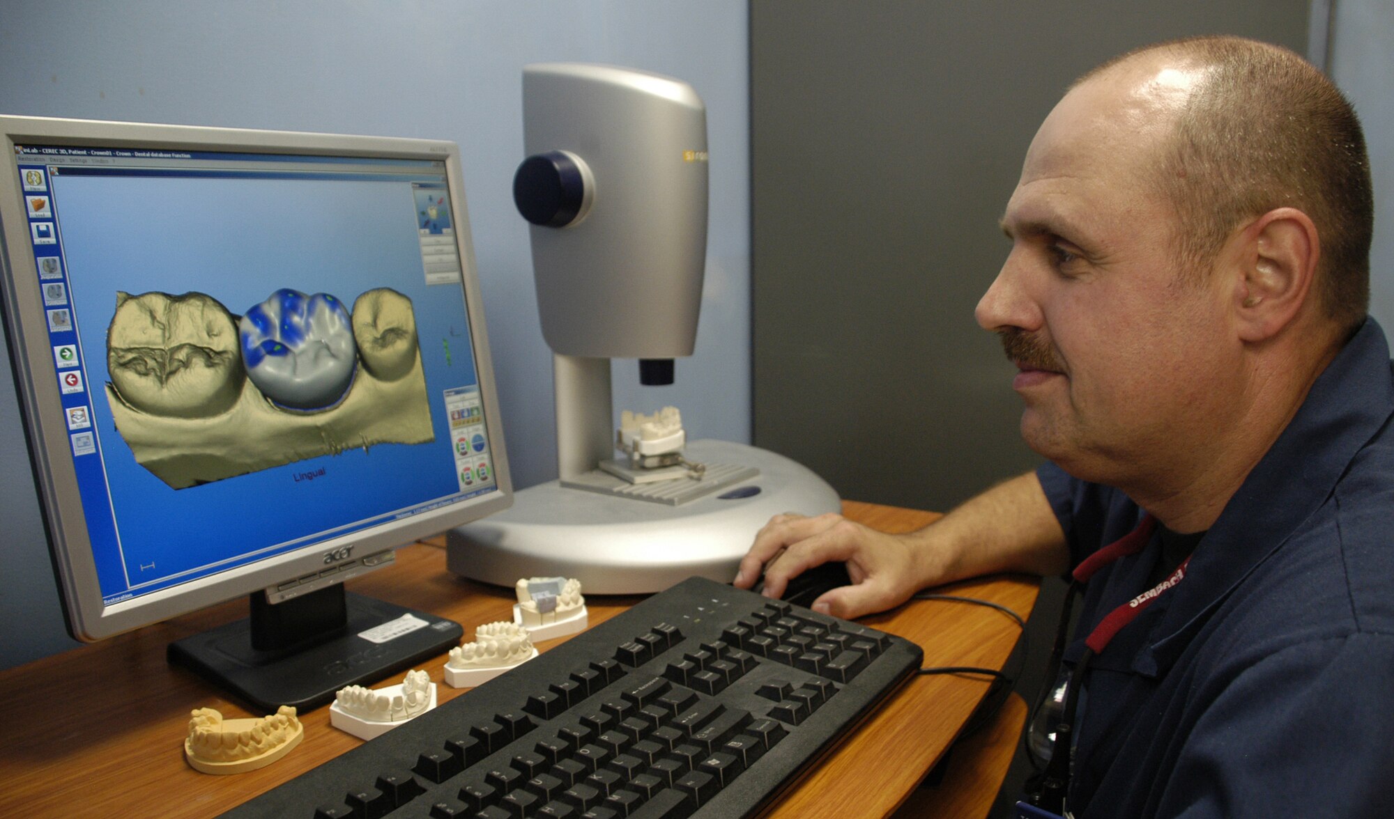 DOVER AIR FORCE BASE, Del. – Tech. Sgt. Raymond Worl, 436th Dental Squadron NCO in-charge of the dental laboratory, uses a three-dimensional digital computerized milling unit incorporating Computer-Aided Design technology to fabricate all-porcelain crowns for difficult dental cases. Sergeant Worl uses the computer to scan the patient's tooth preparation area. This scan produces a 3-D replica of the patient's mouth displayed on the computer and is used to mill the all-porcelain crown. The lab tech is able to make adjustments such as size, contour, and anatomy before actually milling. (U.S. Air Force photo/ Airman 1st Class Shen-Chia Chu) 
