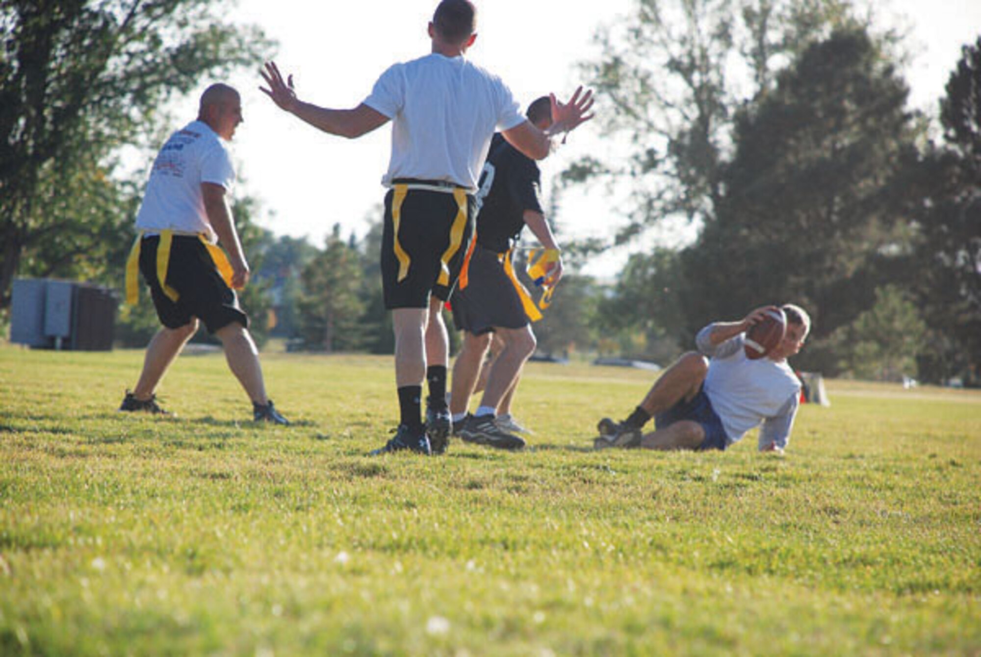 A member of the operations group team accidently knocks Conrad to the ground. A fellow CE member throws up his hands to show he had no part in the illegal tackle.   (Photo by Airman 1st Class Daryl Knee)