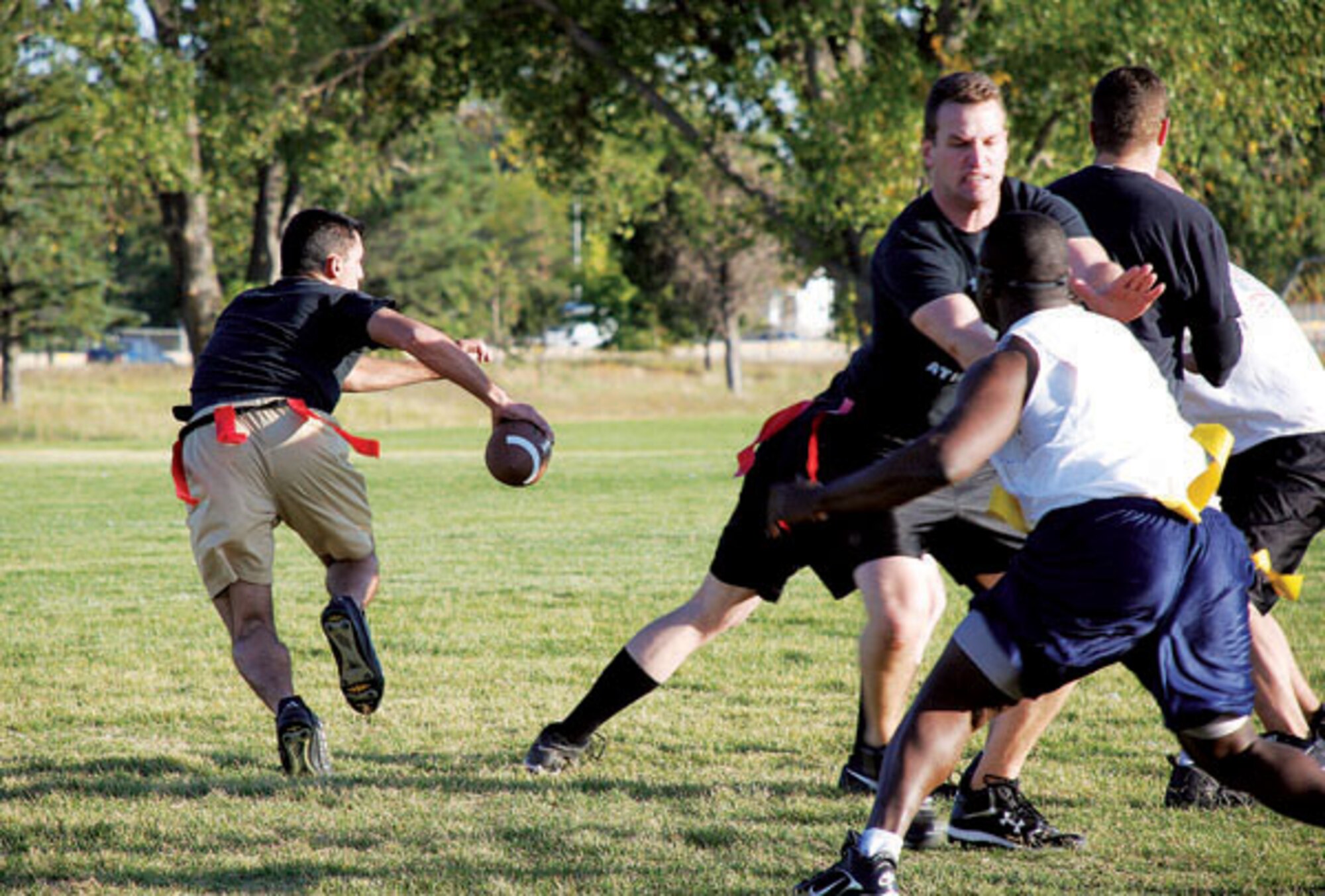 The 90th Operations Group quarterback Trevor Burnham relies on his guard to block the 90th CES's rush. CE's defense was too much for the operations group team; CE stifled any chance OG had to score.  (Photo by Airman 1st Class Daryl Knee)