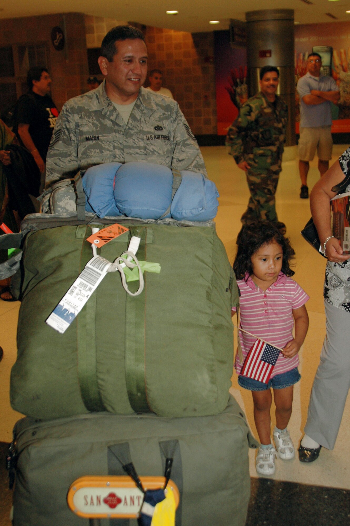 A member of the 433rd Civil Engineer Squadron is welcomed home after six months in Afghanistan Sept. 22 in San Antonio. Family and friends met them at the San Antonio Airport with banners and cheers. The Airmen built and repaired structures at Bagram Airfield, Afghanistan, and forward operating locations. They installed air-conditioning units for Soldiers and brought older buildings up to U.S. military construction codes. (U.S. Air Force photo/Master Sgt. Daniel Nathaniel) 