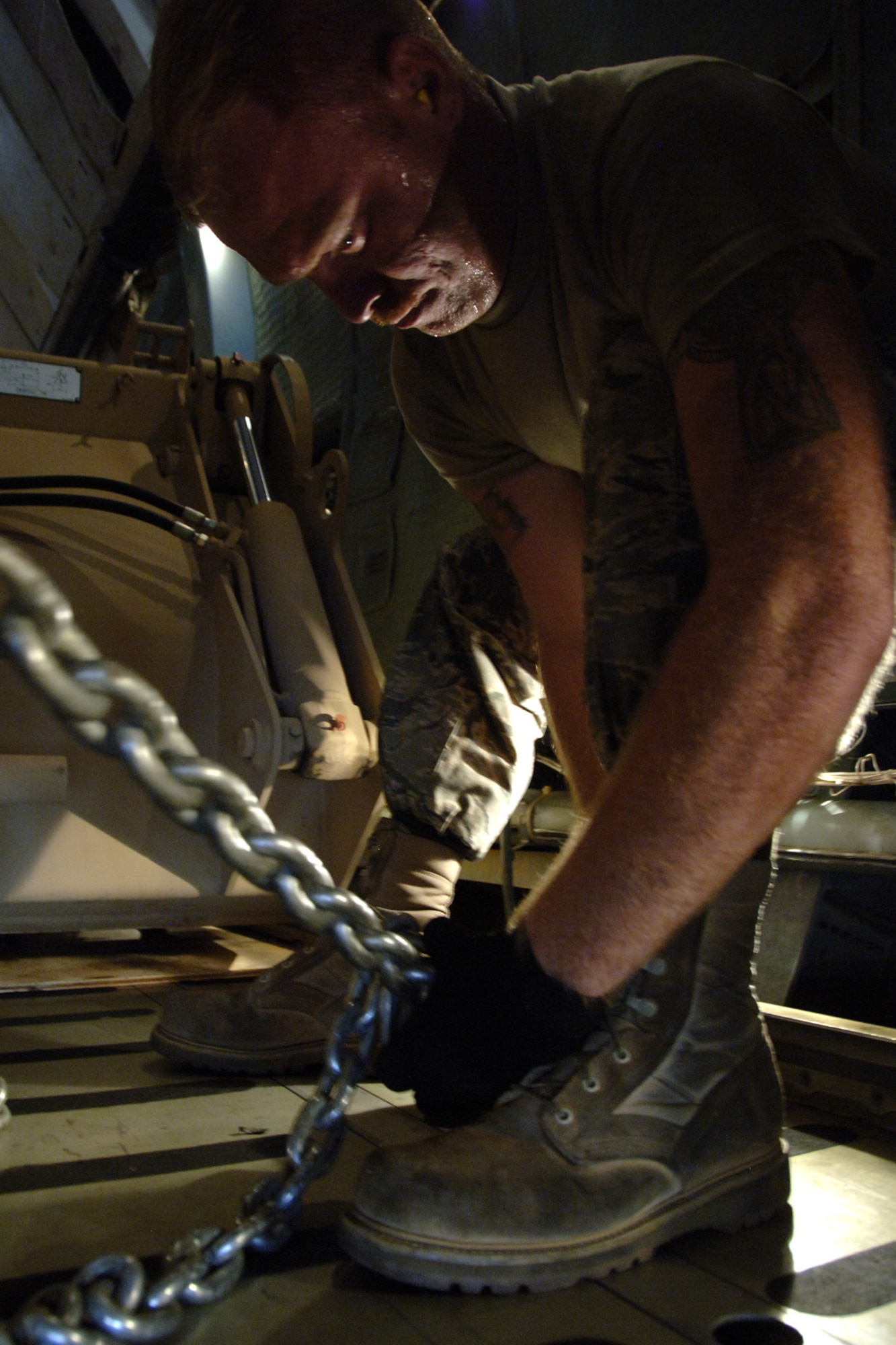 Senior Airman Jared Parsons tightens a clamp to secure an HMEE to the bed of a C-5 before takeoff on the Charleston AFB flight line Sept. 29. The HMEEs will be transported to forward deployed locations to assist Soldiers and contractors in hostile environments. Airman Parsons an air transportation journeyman with the 437th Aerial Port Squadron.  (U.S. Air Force photo/Airman 1st Class Timothy Taylor)