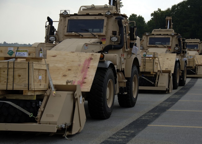 Newly manufactured military High-mobility engineering excavators await the arrival of a  C-5 on the Charleston AFB flightline Sept. 29. The HMEEs will be transported to forward deployed locations to assist Soldiers and contractors in hostile environments. The HMEE is a newly developed military construction vehicle capable of a wide range of mobility affording more protection for the operator than conventional excavators. (U.S. Air Force photo/Airman 1st Class Timothy Taylor)