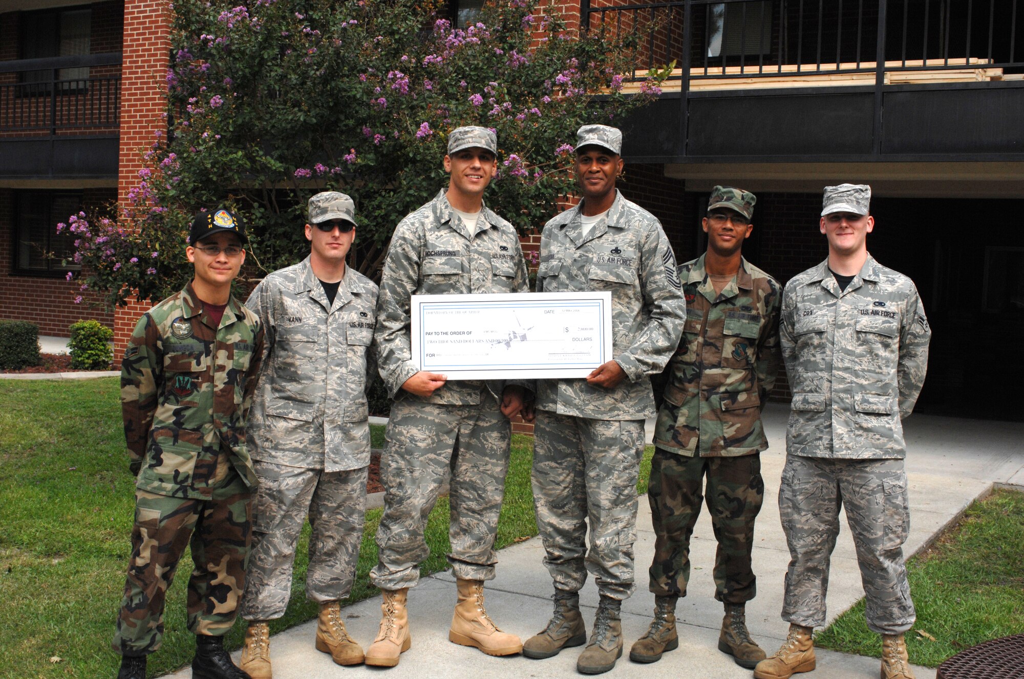 Command Chief Master Sgt.  Leroy Frink presents a check worth $10,000 to the dorm council of building 3616 for winning the dorm of the quarter competition. The council will use the funds to build a game room for the occupants of the dormitory. (U.S. Air Force photo by Airman 1st Class Gino Reyes)