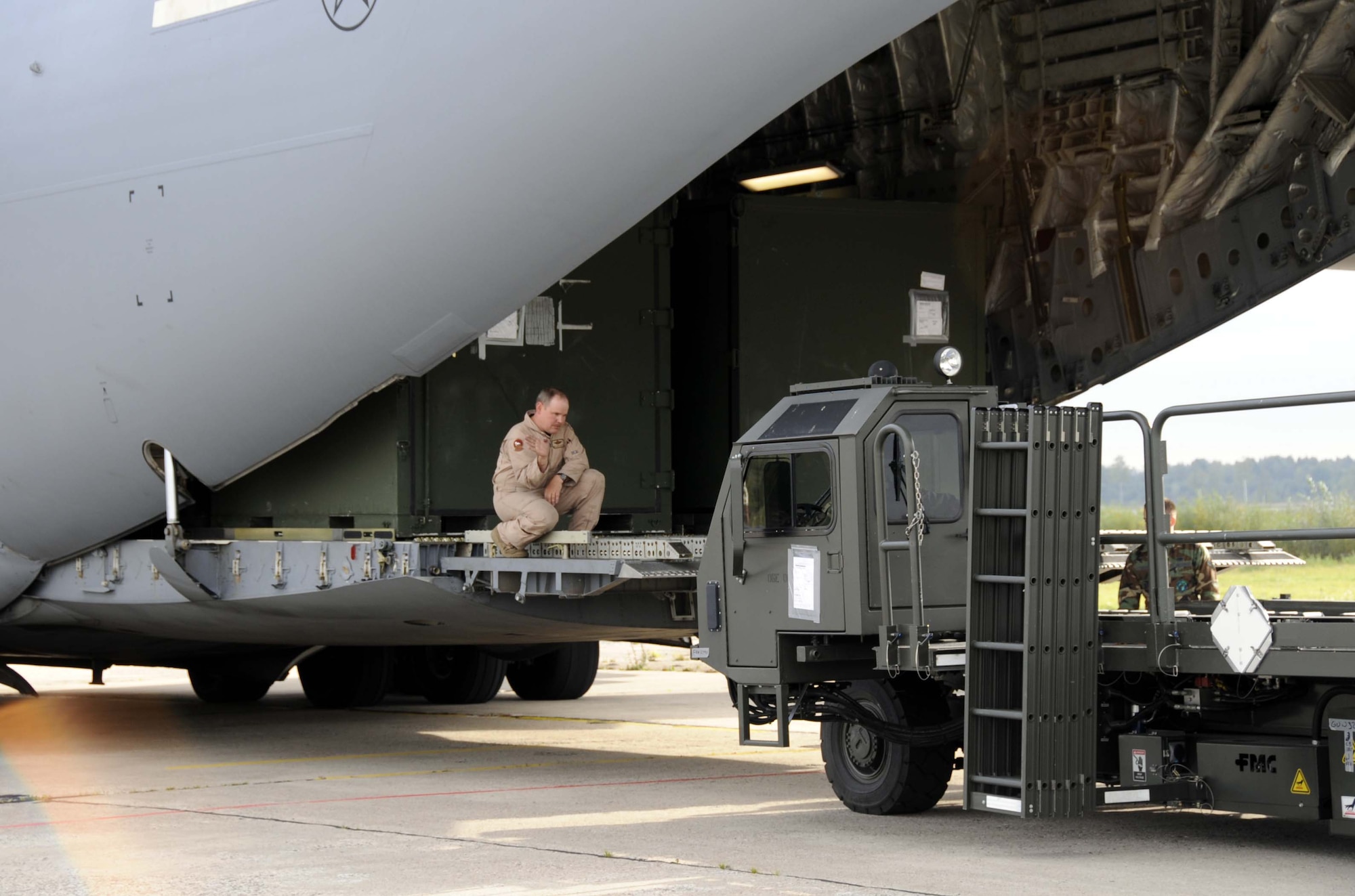 Senior Master Sgt. Lance Gustafson, C-17 loadmaster, prepares to offload cargo in Lithuania to support the NATO Baltic air policing mission. (U.S. Air Force photo by Tech. Sgt. J. LaVoie)