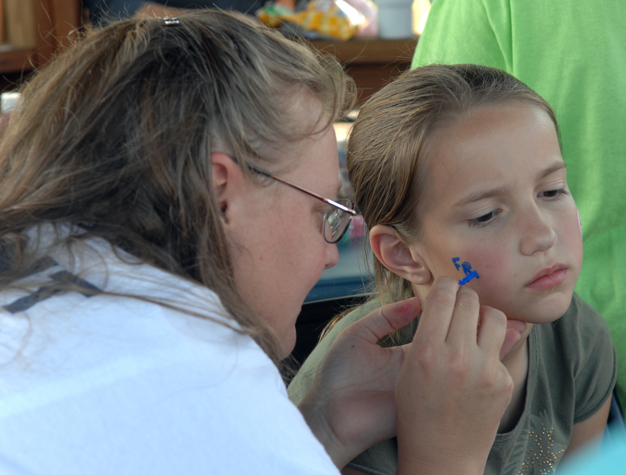 WHITEMAN AIR FORCE BASE, Mo. – Alexis Hornback, daughter of Lori and Chief Master Sgt. Brian Hornback, 509th Bomb Wing Command Chief Master Sergeant, has her face painted by Bonnie Duke, Whiteman Youth Center, during Whiteman Kid’s Day Sept. 27. More than 500 parents and children participated in Whiteman Kid’s Day, which consisted of activities such as face painting, football, bingo, jumping in a bouncy castle and had visits from Sparky the fire dog, Smokey the bear and McGruff the crime dog. Quiznos provided lunch and the United Service Organizations provided drinks. (U.S. Air Force photo/Senior Airman Stephen Linch)