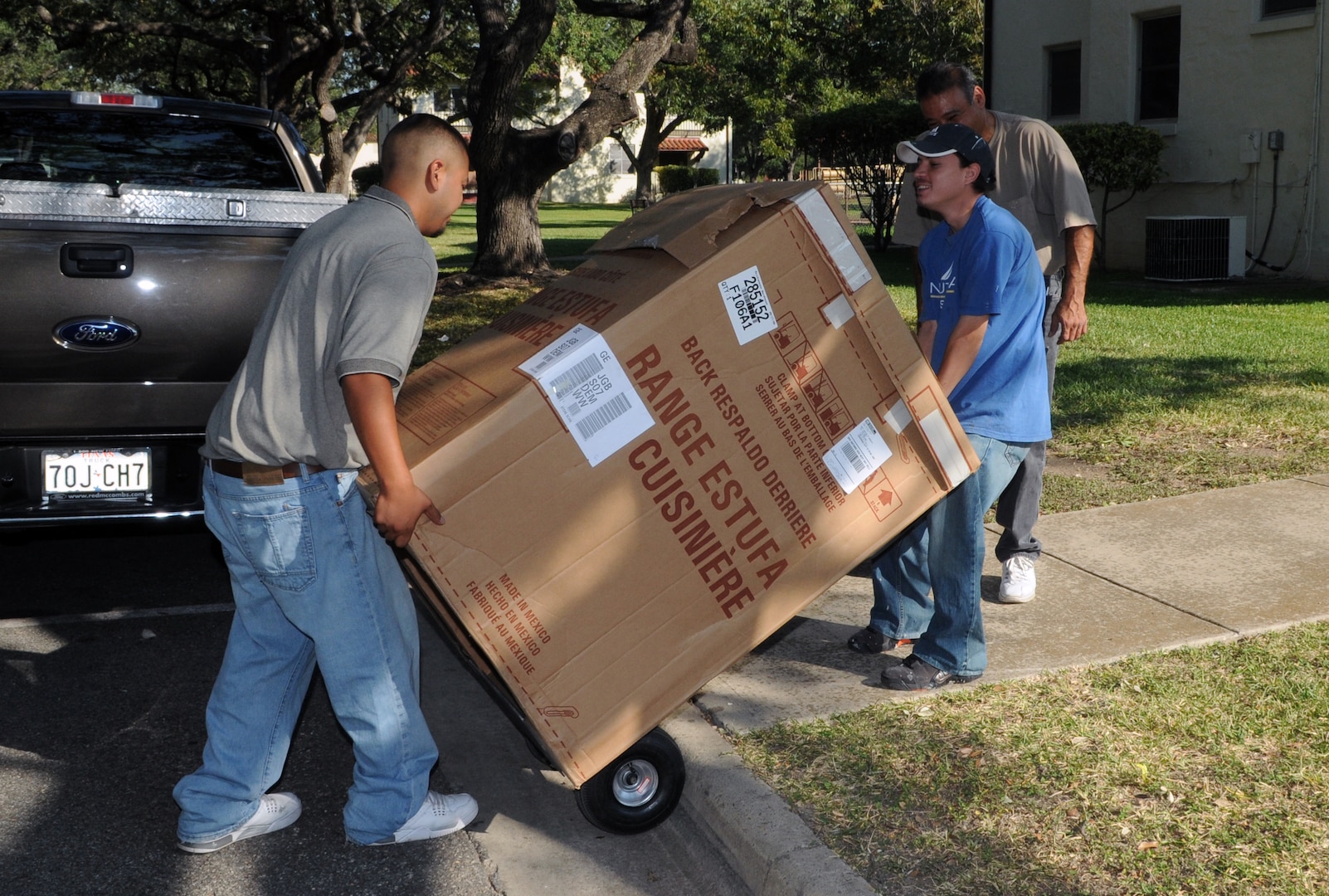 Tomas Amaya (left) and Juan Castillo move a stove into a base home Sept. 30. (U.S. Air Force photo by Rich McFadden)