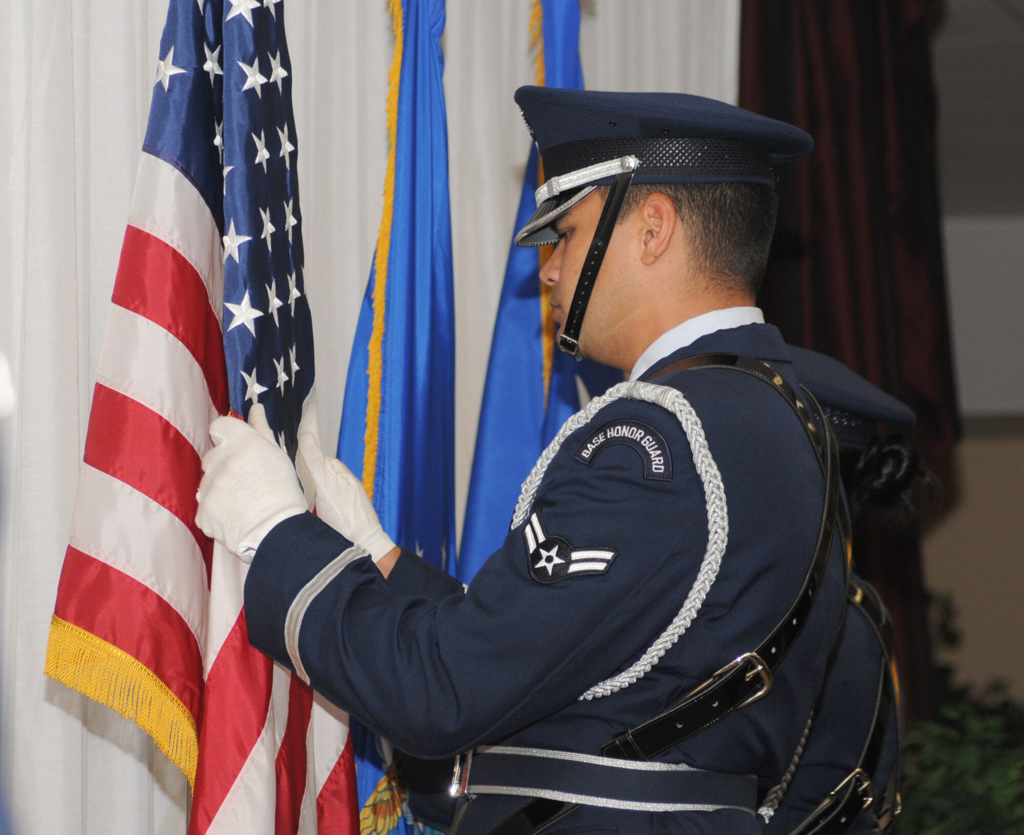 Airmen 1st Class Raul Gesmundo, 81st Dental Squadron, straightens the flag at a promotion ceremony.  (U.S. Air Force photo by Kemberly Groue)