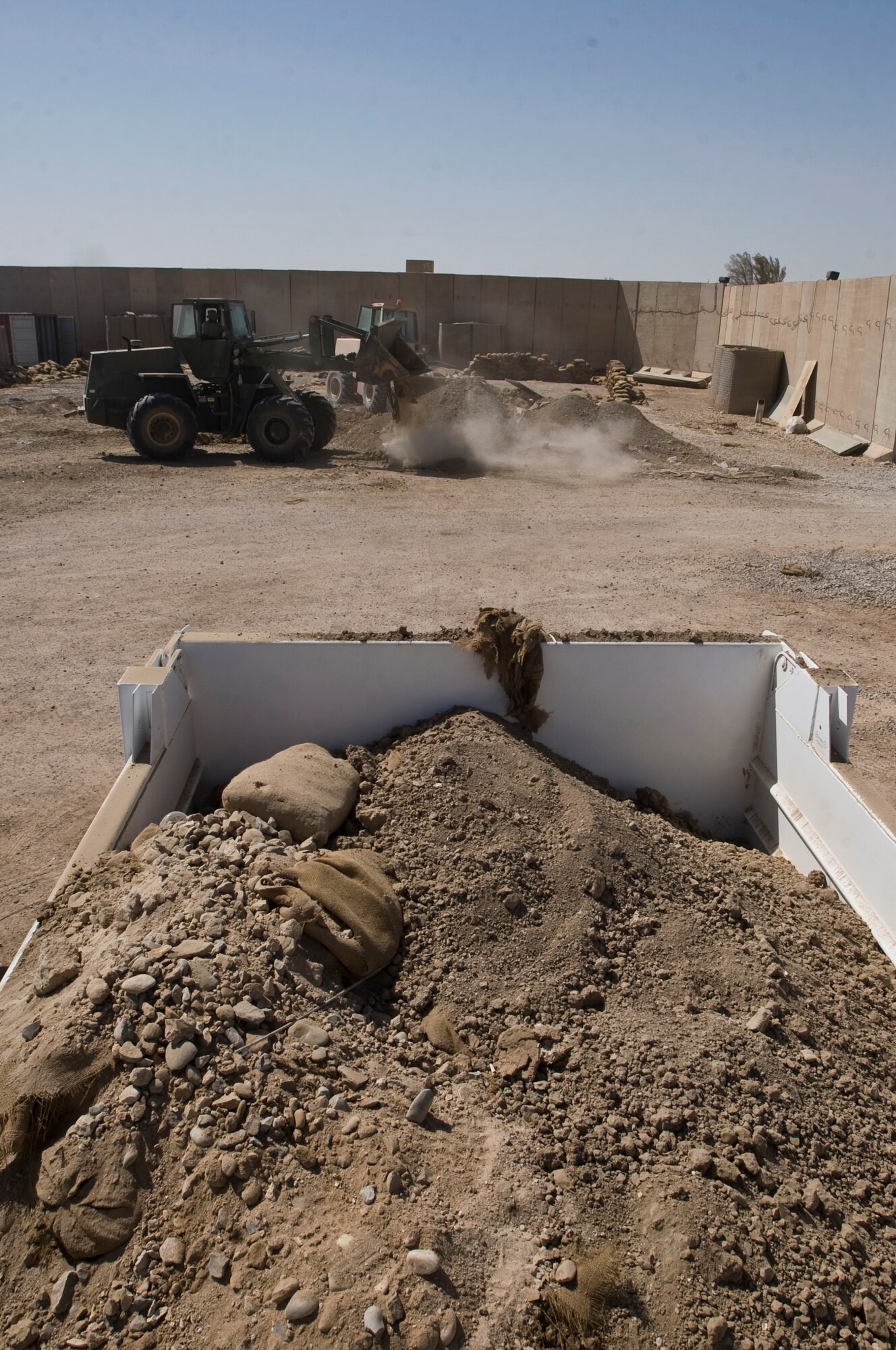 ALI BASE, Iraq -- Staff Sgt. Leonard Rodriguez, 407th Expeditionary Civil Engineer Squadron heavy equipment operator, tears down barricades at the old force protection site Sept. 30, 2008. Airmen of the 407th ECES aided the force protection unit to move to a new location, along with tearing down remaining barricades. Rodriguez is deployed from Malmstrom Air Force Base, Mont. (U.S. Air Force photo/Airman 1st Class Christopher Griffin)