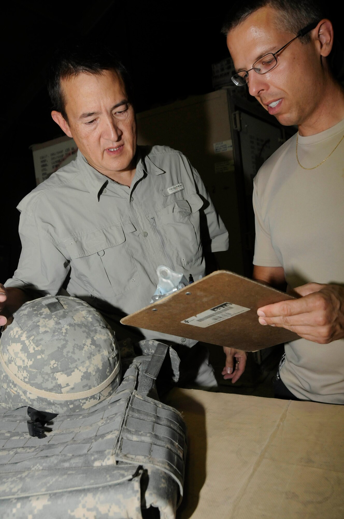Mr. Ron Lee, logistical representative assigned to the Combined Air and Space Operations Center, conducts an inspection of combat protective gear while Mr. Jim McGreevy, also assigned to the CAOC, writes down any defects and the identifying information on an inventory sheet Sept. 29, 2008, at an undisclosed air base in Southwest Asia.  Mr. Lee, a native of Columbia, Md., is deployed from Fort Meade, Md., and Mr. McGreevy, a native of Fort Meade, Md., is deployed from Fort Meade, Md.  Both are deployed supporting Operations Iraqi and Enduring Freedom and Joint Task Force-Horn of Africa. (U.S. Air Force photo by Staff Sgt. Darnell T. Cannady)
