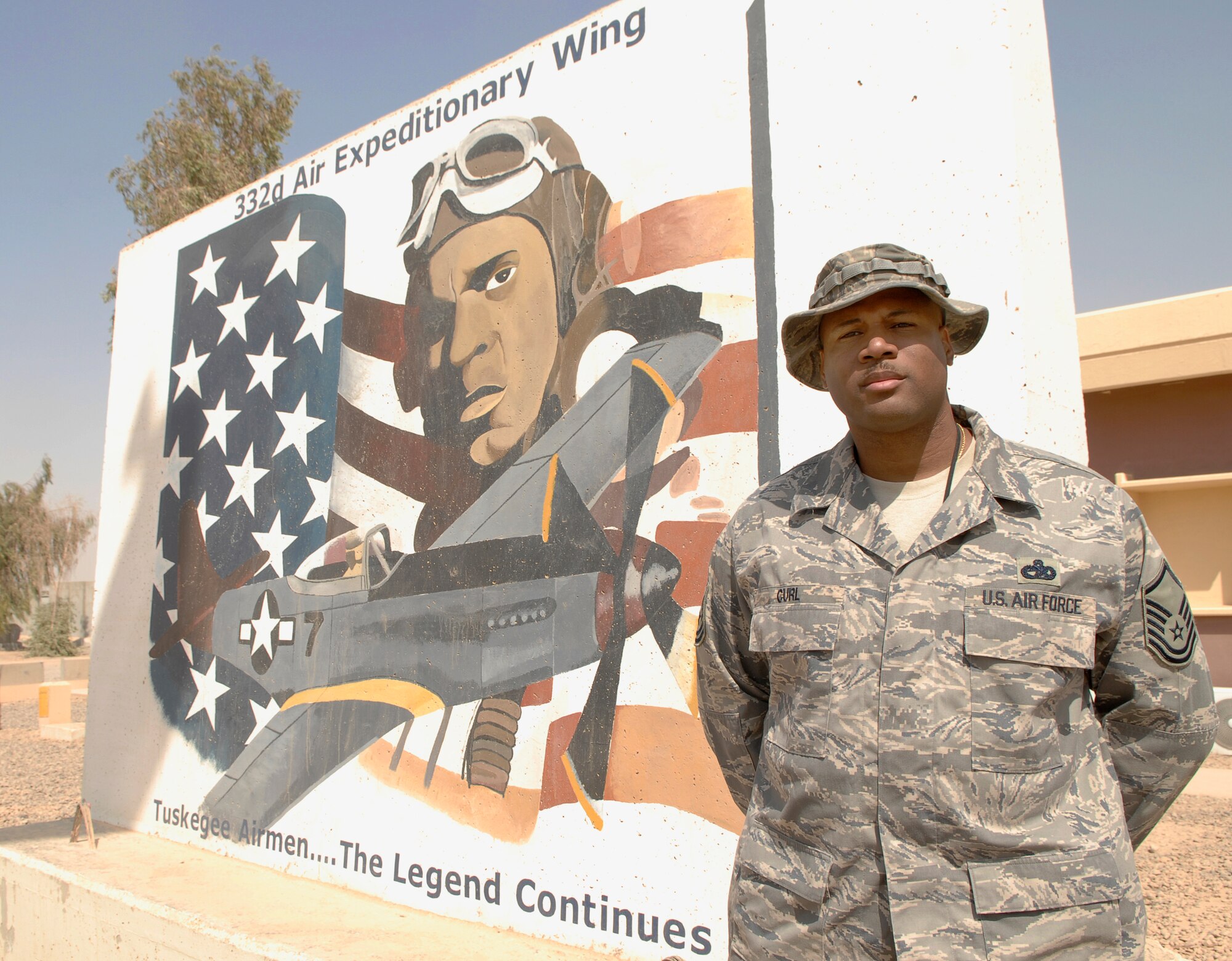 Master Sgt. Jonathon Curl poses for a photograph in front of the 332nd Air Expeditionary Wing headquarters building at Joint Base Balad, Iraq, Sept. 30. Curl's grandfather, Staff Sgt. Cecil Curl, was a crew chief during World War II for the U.S. Army Air Forces original Tuskegee Airmen: the 332nd Fighter Group. Jonathon Curl, the chief of passenger travel for the 332nd Expeditionary Logistics Readiness Squadron and a San Antonio native, is deployed from Kadena Air Base, Japan. (U.S. Air Force photo/Tech. Sgt. Erik Gudmundson) 