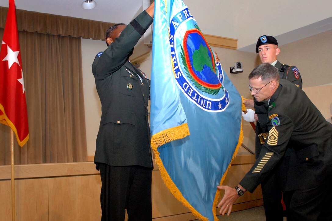 U.S. Army Gen. William E. Ward, Commander, U.S. Africa Command, left, and Command Sergeant Major of the U.S. Africa Command Mark S. Ripka unfold the command's new flag during the Command activation ceremony in the Pentagon, Oct. 1, 2008.
