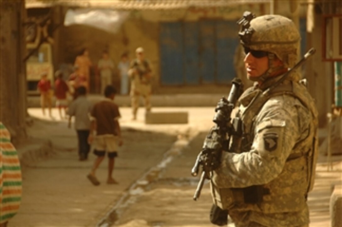 U.S. Army Sgt. William Garett provides security for a visiting dignitary inspecting the market place in Mahmudiyah, Iraq, on Sept. 17, 2008.  Garett is assigned to Alpha Battery, 3rd Battalion, 320th Field Artillery, 101st Airborne Division.  
