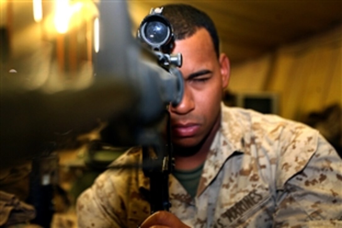 U.S. Marine Corps Lance Cpl. Manuel E. Cuello looks down the barrel of his rifle for obstructions on Asad Air Base, Iraq, Sept. 28, 2008. Cuello is an armory custodian assigned to Company G, 2nd Battalion, 25th Marines Regiment, Regimental Combat Team 5.