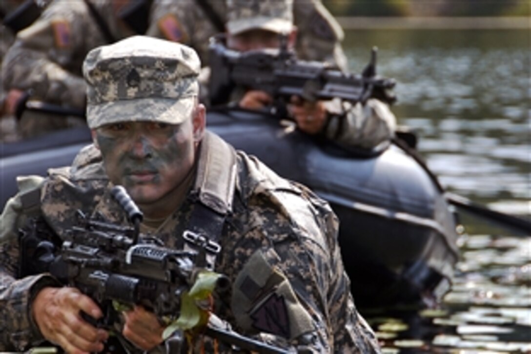U.S. Army Staff Sgt. James Gibson scans the terrain while his battle buddies keep a watchful eye from the water during training on Camp Atterbury, Ind., Sept. 20, 2008. The soldiers are assigned to 2nd Battalion, 152nd Cavalry Reconnaissance and Surveillance Squadron Airborne.