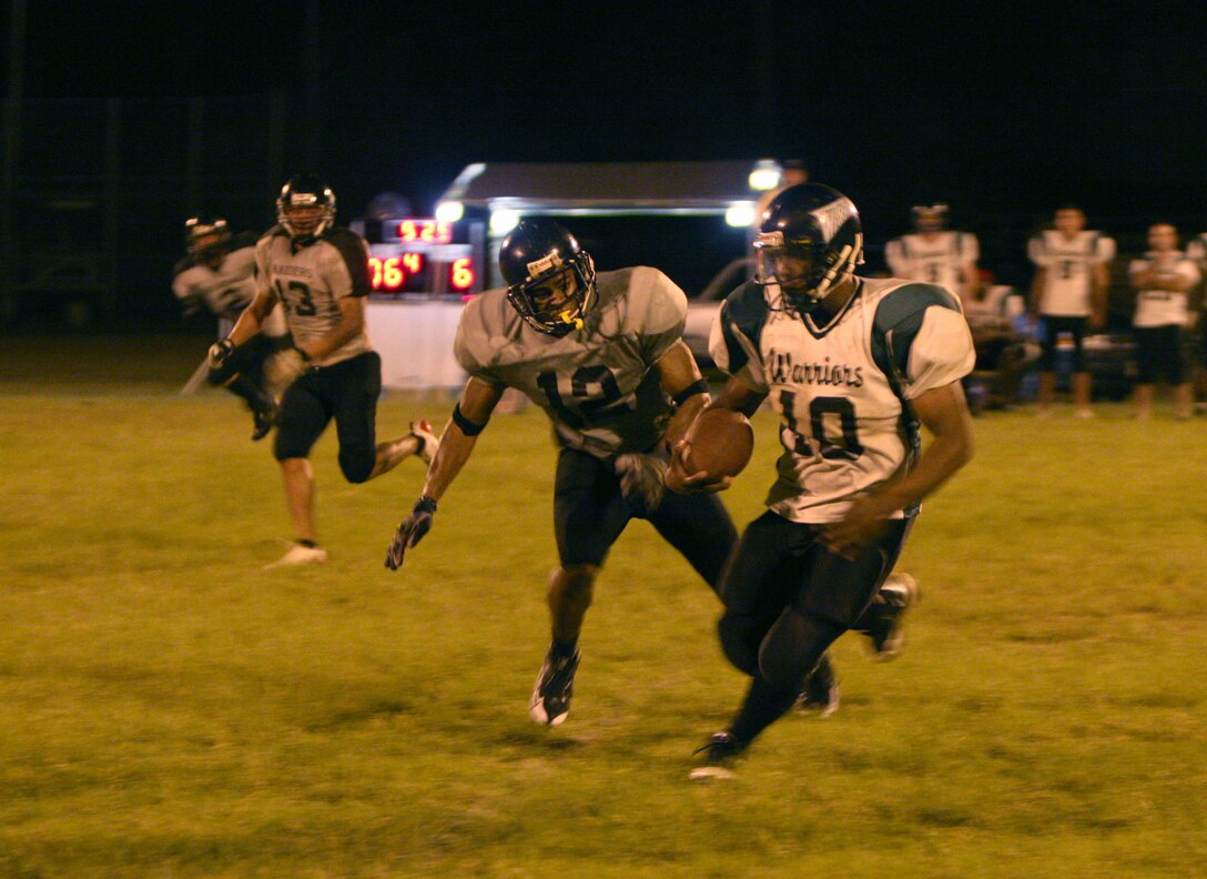 Camp Smith Raiders safety Deshaun Brandy hounds Combat Logistics Battalion 3 Warriors wide receiver Joushua Brown as he attempts a run for the end zone during a 2008 Intramural Football League game at Bordelon Field here Oct. 1.::r::::n::The Raiders defeated the Warriors 12-6.
