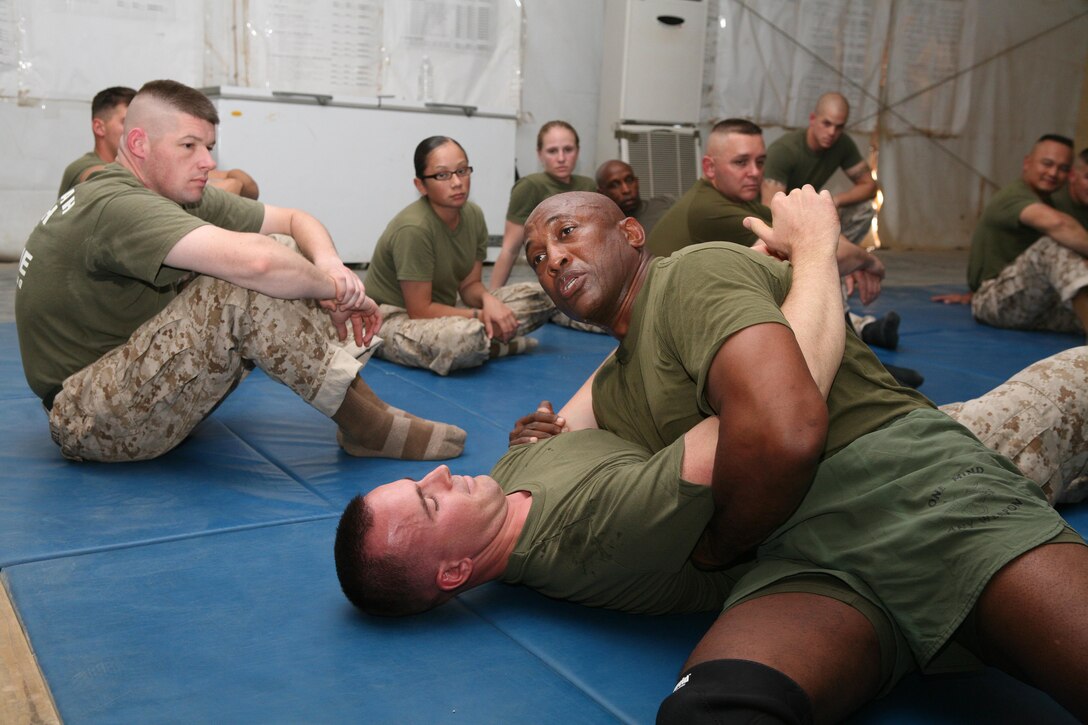 CAMP FALLUJAH, Iraq -- Sgt. Maj. Larock W. Benford, I Marine Expeditionary Force's Ground Combat Element's 47-year-old sergeant major, demonstrates wrestling techniques to the service members of I MEF Headquarter Group (Forward)'s most recent martial arts instructor course Oct. 2.  Benford was one of many guest instructors who took their time to teach the 95 service members who attended the Marine Corps Martial Arts Program MAI class on Camp Fallujah.  (Photo by Cpl. Sean P. McGinty)