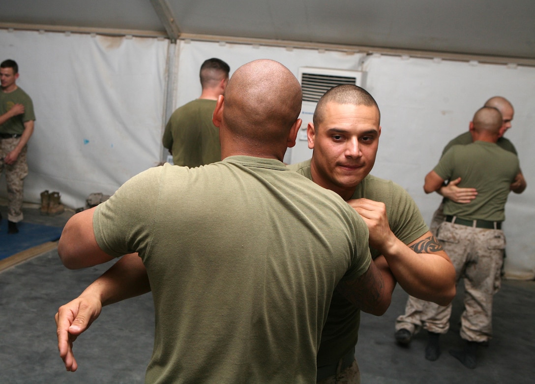 CAMP FALLUJAH, Iraq -- Sgt. Richard Palacios, a 25-year-old I Marine Expeditionary Force Headquarters Group (Forward) Truck Company motor transport operator, practices 'pummeling,' a wrestling technique taught by Sgt. Maj. Larock W. Benford, the 47-year-old I MEF Ground Combat Element sergeant major, Oct. 2.  Palacios graduated I MHG's recent martial arts instructor course Oct. 3 as a green belt instructor, one of the 95 graduates in the Marine Corps Martial Arts Program's largest ever martial arts instructor courses.  (Photo by Cpl. Sean P. McGinty)