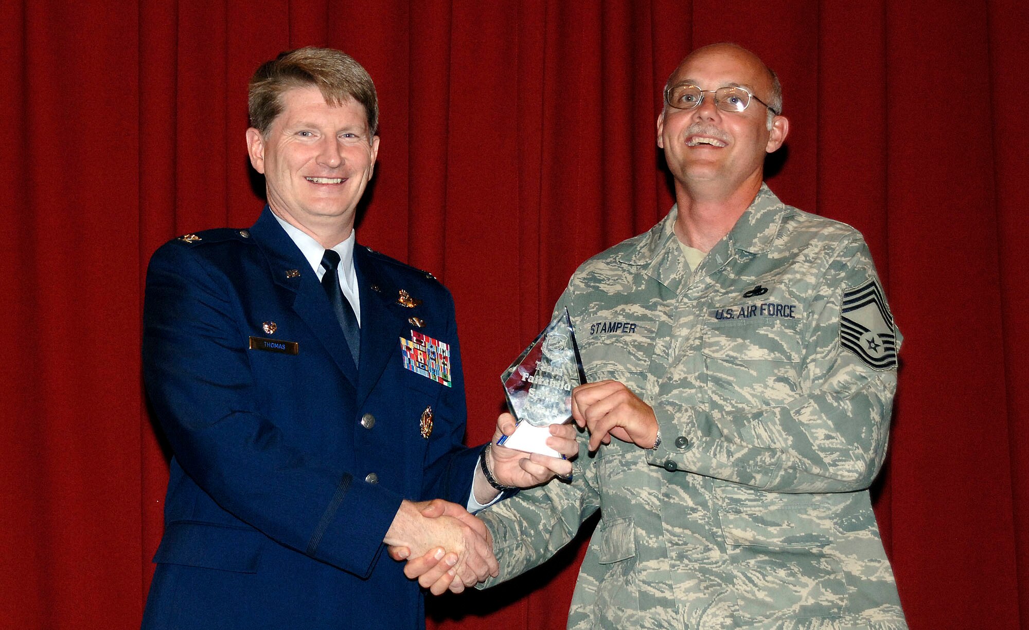 FAIRCHILD AIR FORCE BASE, Wash. – Col. Robert Thomas, 92nd Air Refueling Wing commander, presents Chief Master Sgt. William Stamper, 92nd Maintenance Group superintendent, with the spirit award Sept. 30. The award is given to the squadron that displays the most enthusiasm during the Wing Promotion Ceremony. (U.S. Air Force photo / Staff Sgt. JT May III) 