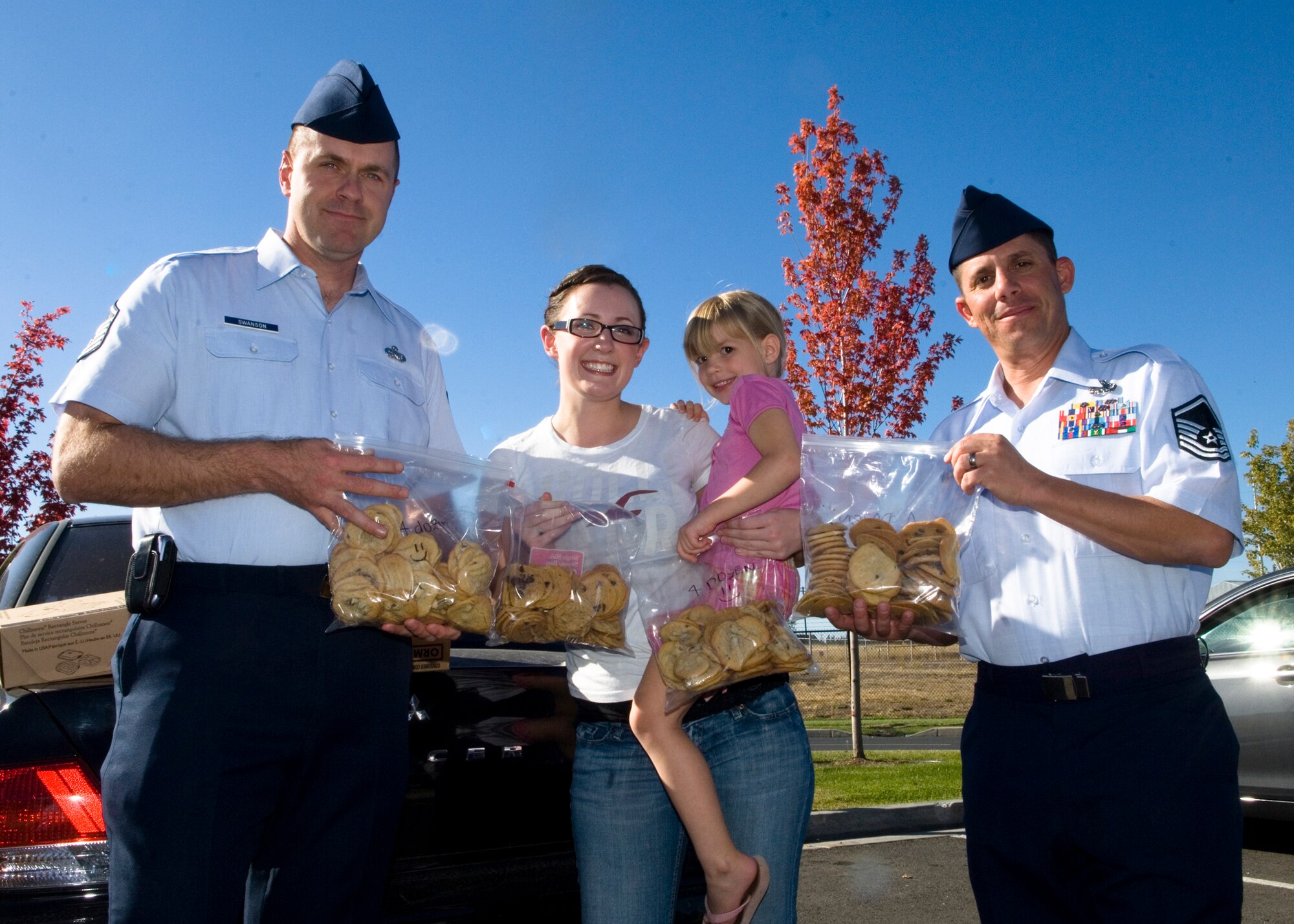 FAIRCHILD AIR FORCE BASE, Wash. – First sergeants Master Sgt. Robert Swanson, 92nd Communications Squadron, and Master Sgt. Todd Berliner, 92nd Maintenance Squadron, pose with Isabel Brick Sept. 29. Miss Brick is a local military supporter and Delayed Entry Program member awaiting orders for the Air Force’s Basic Military Training at Lackland Air Force Base, Texas. Miss Brick baked 1,000 cookies for Fairchild Airmen living in the dormitories. Her reason, she explained, was a natural extension of a random act of kindness, a concept that Miss Brick had recently researched online. “I've been getting donations from people around my neighborhood. Safeway has graciously donated supplies toward the cause, and [I’ve been] asking people at work to donate change at the end of the day,” she said. (U.S. Air Force photo / Airman 1st Class Joshua K. Chapman)