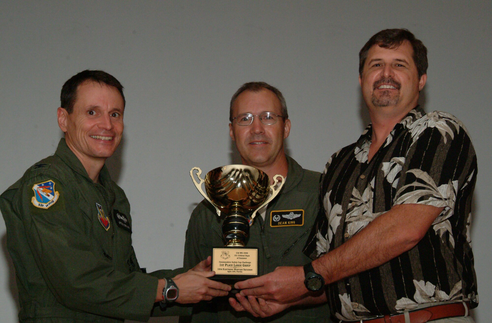 Col. Steve DePalmer, 53d Wing commander, presents the 53d Wing Safety Cup Challenge trophy to Lt. Col. Dean King, 16th Electronic Warfare Squadron commander and Bill Pennell, 16th safety representative, for winning the large group competition of the challenge.  The 16 EWS edged out 53d Wing staff to win its second trophy in a row.  Now a four-time winner, the 29th Test Systems Squadron took home the medium-size unit award.  The closest race was in the small-group contest where the Operational Flight Program Combined Test Force narrowly claimed victory over Detachment 3, 29 TSS by only two points.  All the hard work lead to zero fatalities in the wing.  In the nine safety categories, units offered more than 650 submissions.
