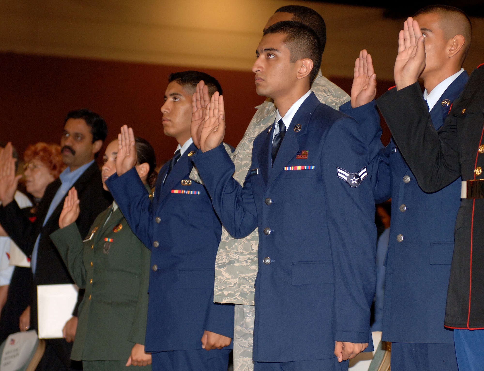 Four members from  Holloman Air Force Base, N.M., take the oath of allegance, along with 17 other servicemembers, during a naturalization ceremony, September 24. More than 1,200 applicants were granted U.S. citizenship at the Convention and Performing Arts Center that was transformed into a federal court room in El Paso, Texas  (U.S. Air Force photo/Airman 1st Class Michael Means)