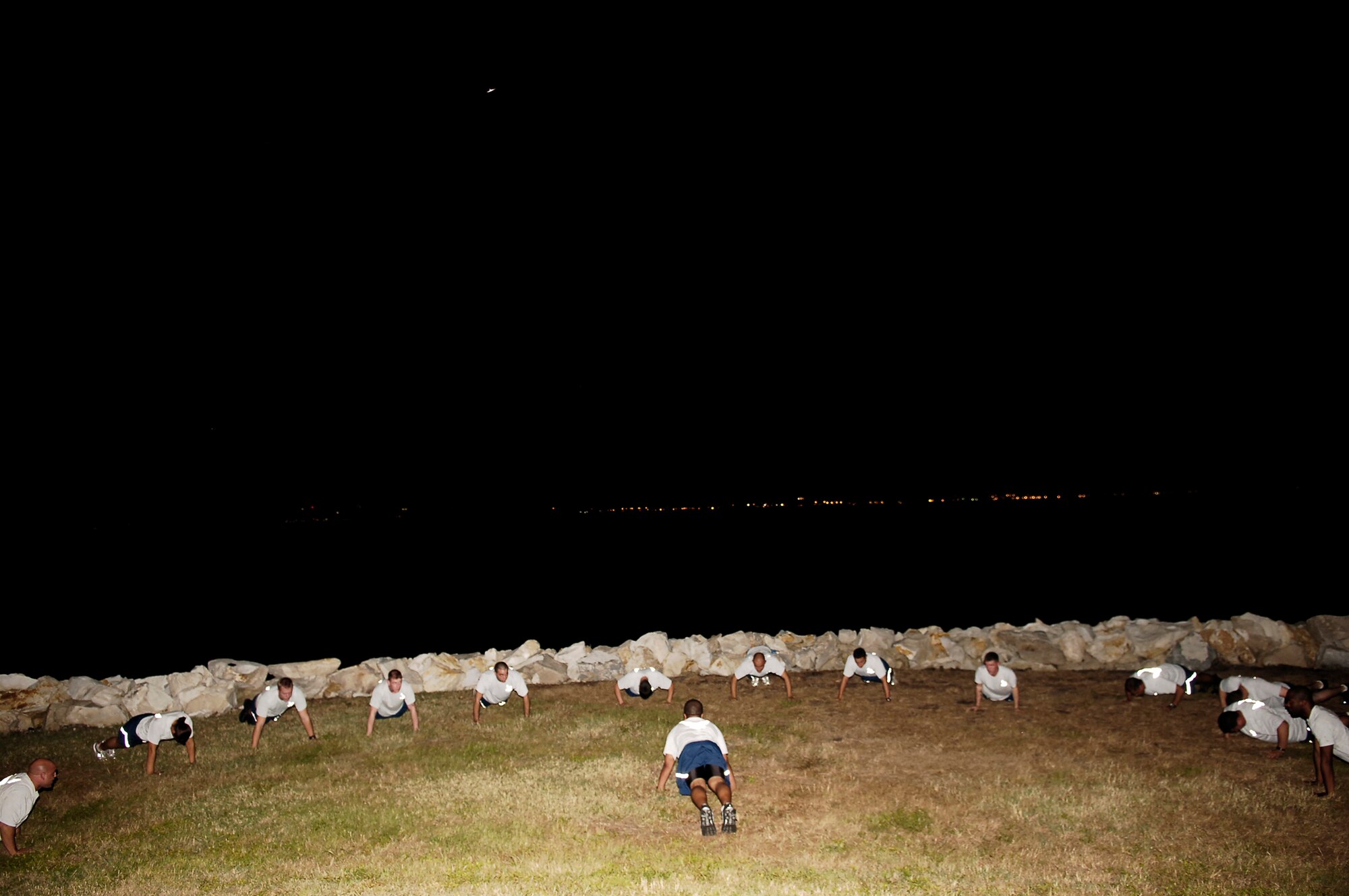 Members of the 6th Security Forces Squadron perform group physical training lead by Senior Airman Alan Evans, at 9:30 p.m. after getting off of shift. The session consisted of stretching, pyramid push-ups and crunches followed by a two mile run along Bay shore Boulevard.  (U.S. Air Force Photo by Tech. Sgt. Sean M. White)