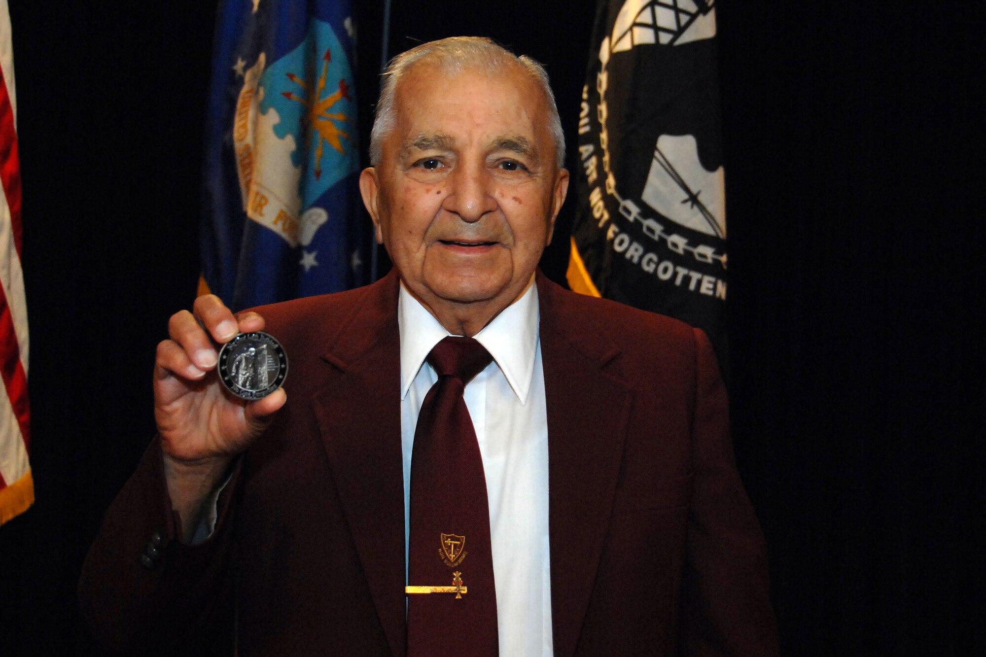 Mr. Salvatore Sambasile shows off his POW/MIA coin. Mr. Sambasile, a gunner on a B-17 aircraft during World War II, was shot down over Berlin and then spent seven months in a Nazi prison camp.  He and his fellow Airmen were rescued by Russian soldiers. Mr. Sambasile attended the 14th Annual First Sergeants Association's POW/MIA Recognition Ceremony at the Patriot Club here Sept. 29. (U.S. Air Force Photo By Josh Plueger)