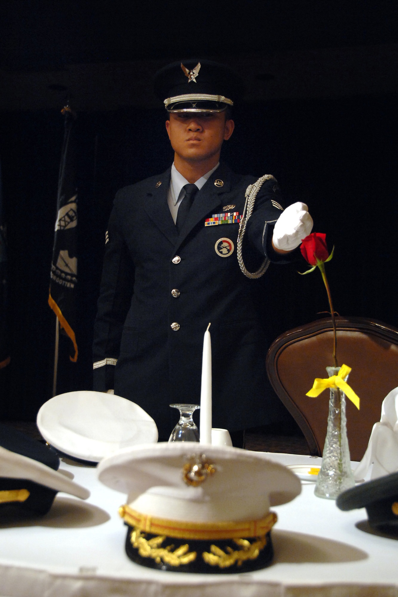 Senior Airman Johnson Xaysana, Offutt AFB Honor Guard member assigned to the 55th Force Support Squadron, presents the POW/MIA table during the 14th Annual First Sergeants Association's POW/MIA Recognition Ceremony at the Patriot Club here Sept. 29. The POW/MIA table is set with very specific symbolic items such as a slice of lemon to represent the bitter fate of prisoners of war or those missing in action, a pinch of salt to represent the tears shed by the one missing or captured and their family and an inverted glass showing the inability of those listed as POW/MIA to share in the toast for the evening.  (U.S. Air Force Photo By Josh Plueger)