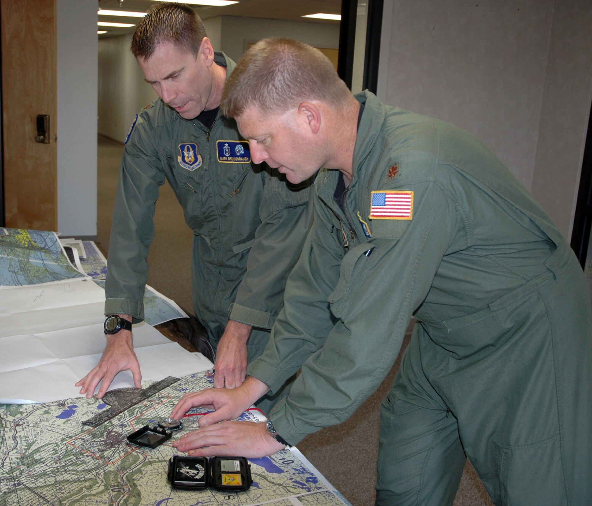 BARKSDALE AFB, LA— Air Force Reservists Majors Mark Breidenbaugh and Karl Haagsma (left to right), medical entomologists with the 757 Airlift squadron, 910th Airlift Wing, Youngstown, Ohio, discuss areas to be aerial sprayed over Terrebonne Parish, LA.  Entomologist duties include identifying target pests, defining areas to be aerial sprayed, prescribing treatment rates and chemicals to be applied, and accompanying flight crews on spray missions to ensure proper pesticide application.  The 757 AS was tasked September 13 with the aerial application of pesticides to control insects capable of transmitting disease.  The 757 AS flies specially equipped Lockheed C-130s with Modular Aerial Spray Systems. The aerial spray unit treated seven parishes comprised of more than 750, 000 acres Sept 21 to October 2.  U.S. Air Force photo/Capt. Brent J. Davis 