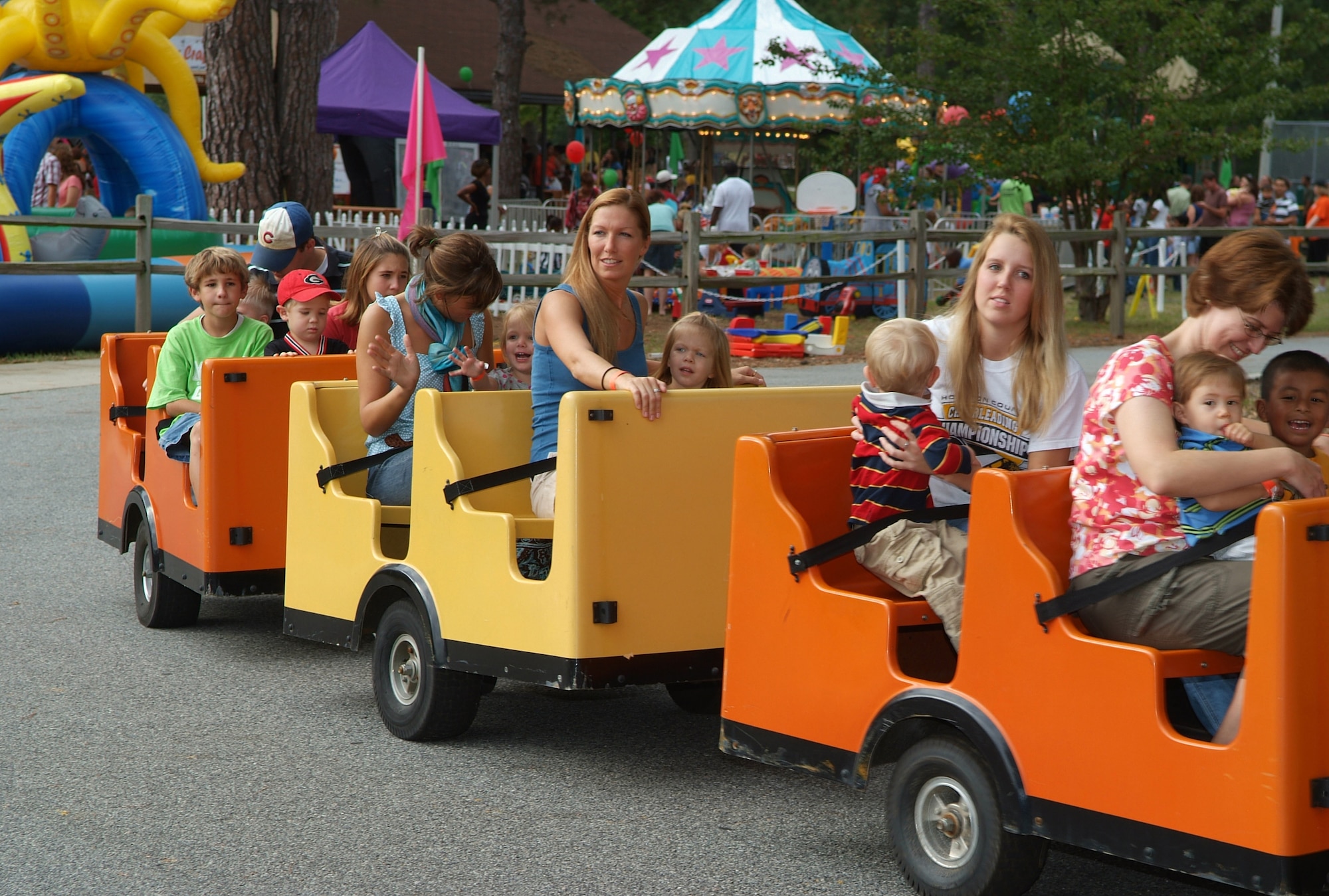 Bash attendees ride a train, one of the many attractions at the Summer Bash.  Other attractions and rides included a roaring dual lane water slide, cars two lane slide, rock and joust, carousel, Wacky World Playland, Jungle Combo and three lane bungee run.  U. S. Air Force photo by Gary Cutrell