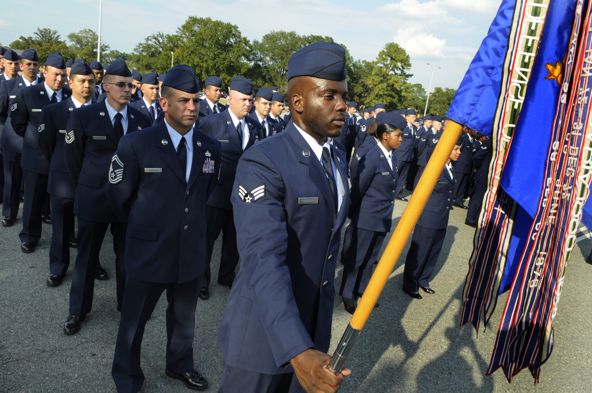 SrA Trevor Corriders, guidon bearer for the 5th Combat Communications Group, stands before their formation at the formal retreat Sept. 29 honoring the 60th Anniversary of the integration of the United States Armed Forces. U. S. Air Force photo by Sue Sapp