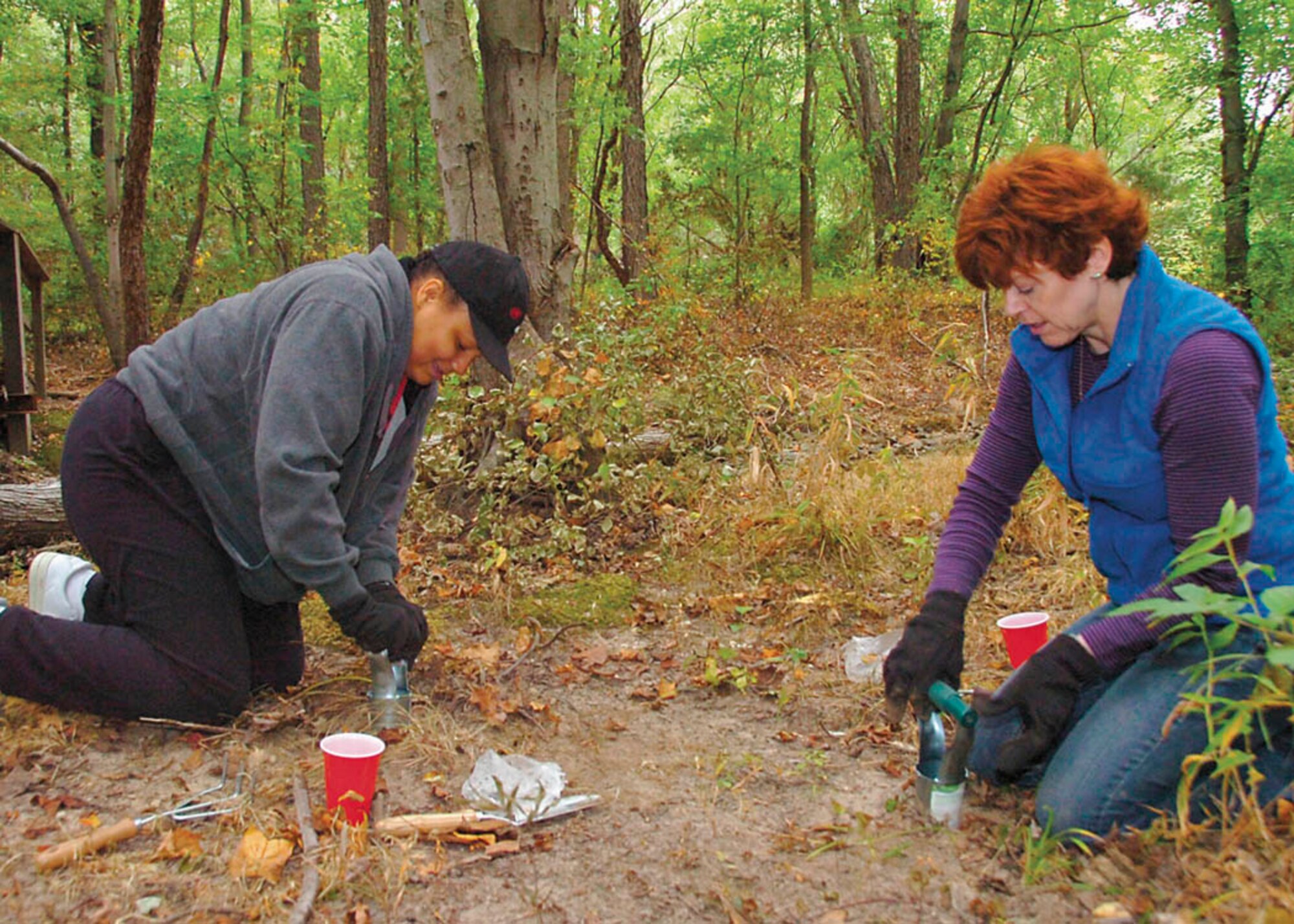 Staff Sgt. Tanisha Fleshman, left, 579th Dental Squadron dental laboratory technician and Terri Bedford, 316th Force Support Squadron’s Education Office guidance counselor, plant tulips, Iris and Lilies to help spruce up at wetland area at Yuma Park Sept. 25 in honor of National Public Lands Day.  (USAF photo by Bobby Jones)