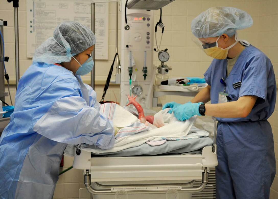 Technicians clean up baby Jae Riley McCoy and assign her an Apgar score at the Maternal Child Unit of Malcolm Grow Medical Center.  To access this score, the technicians evaluated her on skin color, heart rate, reflex irritability, muscle tone and breathing. (USAF photo by Tech. Sgt. Suzanne M. Day)