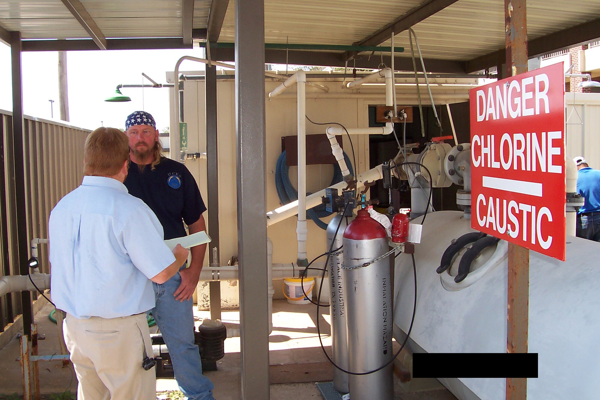 Dennis Ritko, OSHA Voluntary Protection Program advisor, discusses chlorine tank safety with Ed Stepan Sept. 25. (U.S. Air Force photo illustration by Lt. Col. Joseph McBrearty)
