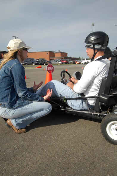 Capt. Kim Floyd, licensed clinical psychologist of the Mental Health Clinic in the 5th Medical Operations Squadron discusses with Airmen the purpose of the Simulated Impaired Driving Experience, and the system?s delayed-response effect.