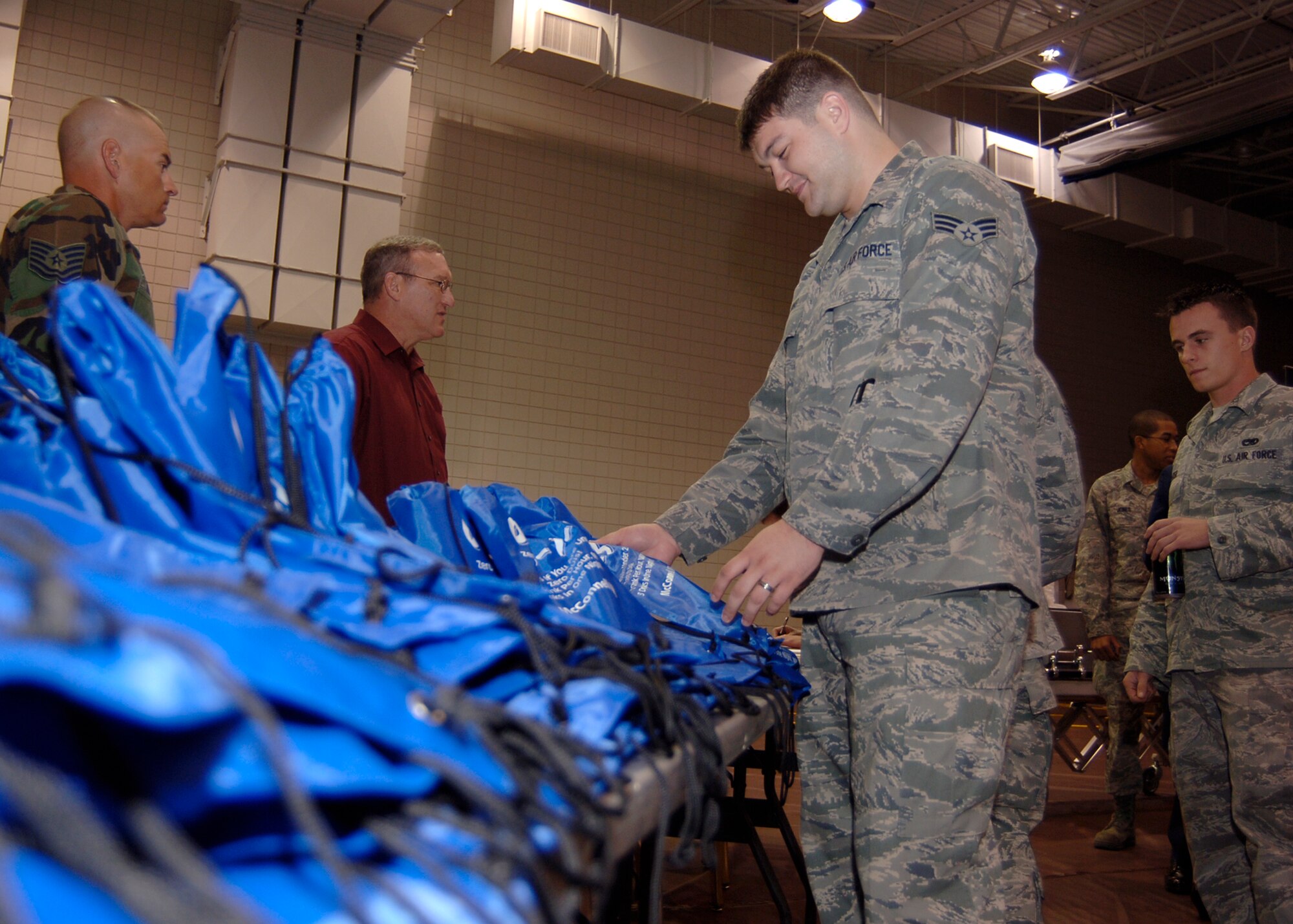 MCCONNELL AIR FORCE BASE, Kan. -- Senior Airman Mitchell Jones, 22nd Judge Advocate, picks up a bag containing pamphlets from the Health and Wellness Center, Alcohol, Drug Abuse Prevention and Treatment program, Sexual Assault Response Coordinator and the Culture of Responsible Choices program, Sept. 30. Airmen received the bags after the drunken driving simulator sessions which contained information about quitting smoking and drug and alcohol abuse (Photo by Airman 1st Class Maria Ruiz)