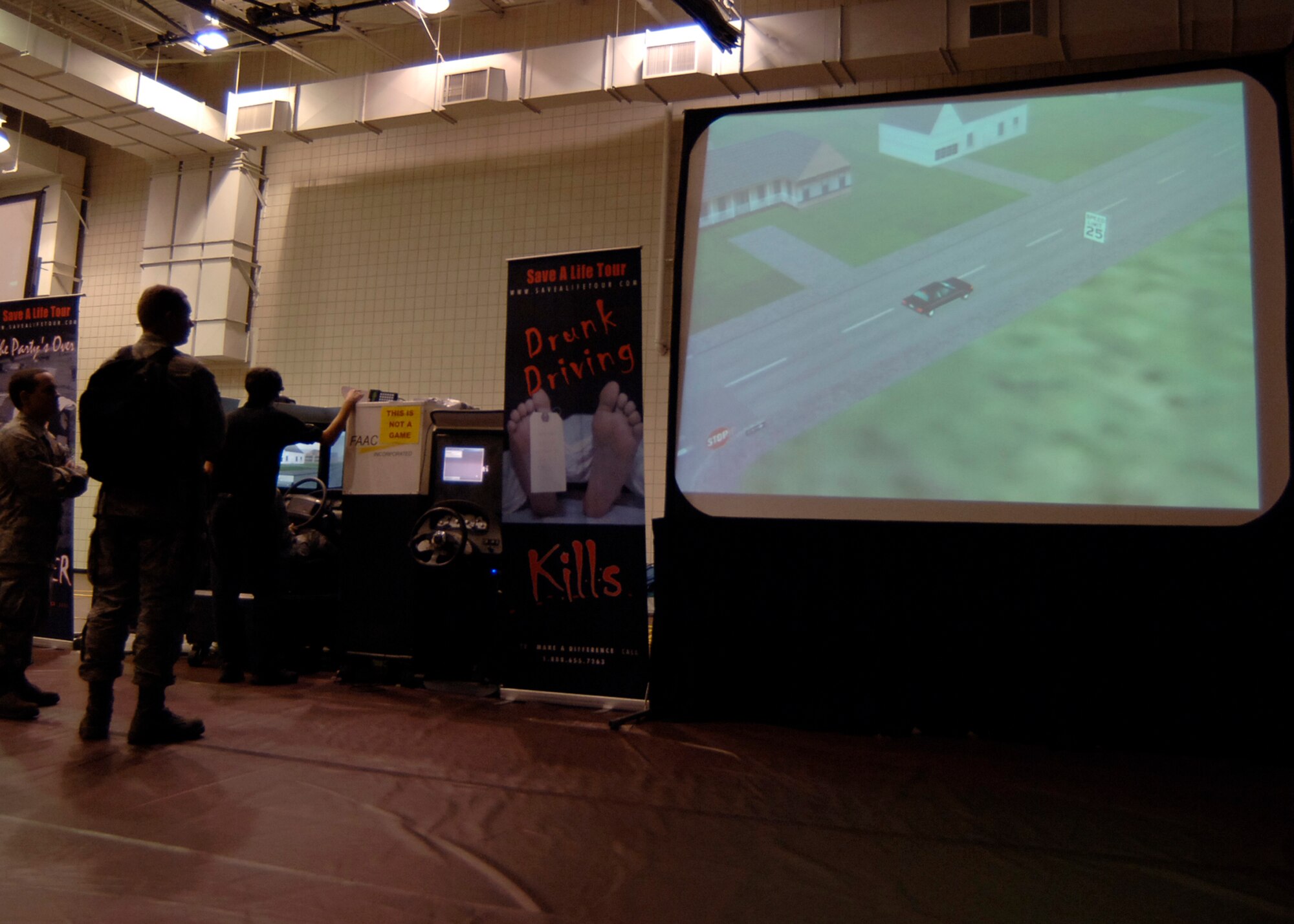 MCCONNELL AIR FORCE BASE, Kan. – Airman Kiana Clark, 22nd Operations Support Squadron, drives the drunken driving simulator as spectators watch her car drive around the city, Sept. 30. The big screen television shows the driver’s driving abilities from a bird’s eye view and onlookers can see the scene as it progresses from regular driving to reckless drunk driving. (Photo by Airman 1st Class Maria Ruiz)