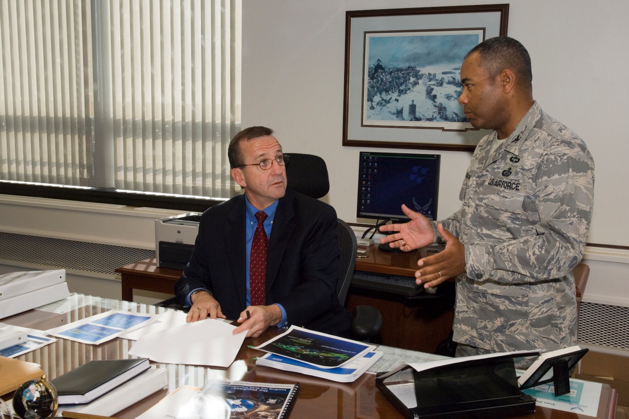 Frank Weber, who will retire Friday as director of the 554th Electronic Systems Wing, chats with Vice Wing Director Col. Derrick Richardson in his office last week. Mr. Weber is a member of the Senior Executive Service and is retiring after 33 years of federal service. (USAF Photo by Rick Berry)
