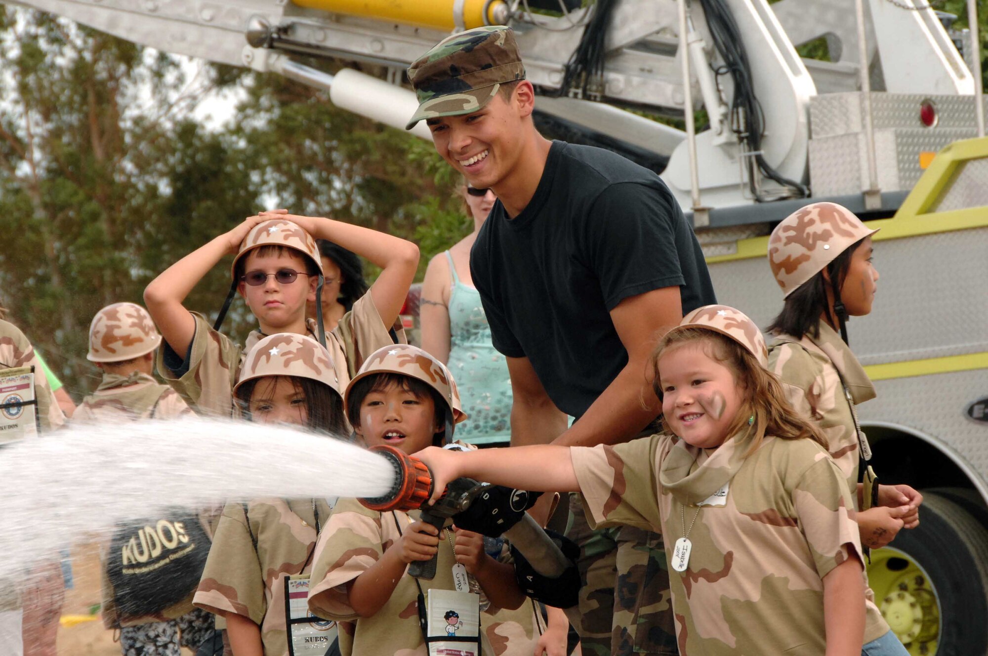 Airman 1st Class Mark McLellan, 60th Civil Engineering Squadron firefighter, shows one element of being a firefighter to a group participating in the Kids Understanding Deployment Operations event.  The event was designed to give family members a realistic observational understanding of what servicemembers go through before, during and after deployments. (USAF photo/Amanda Lopez)