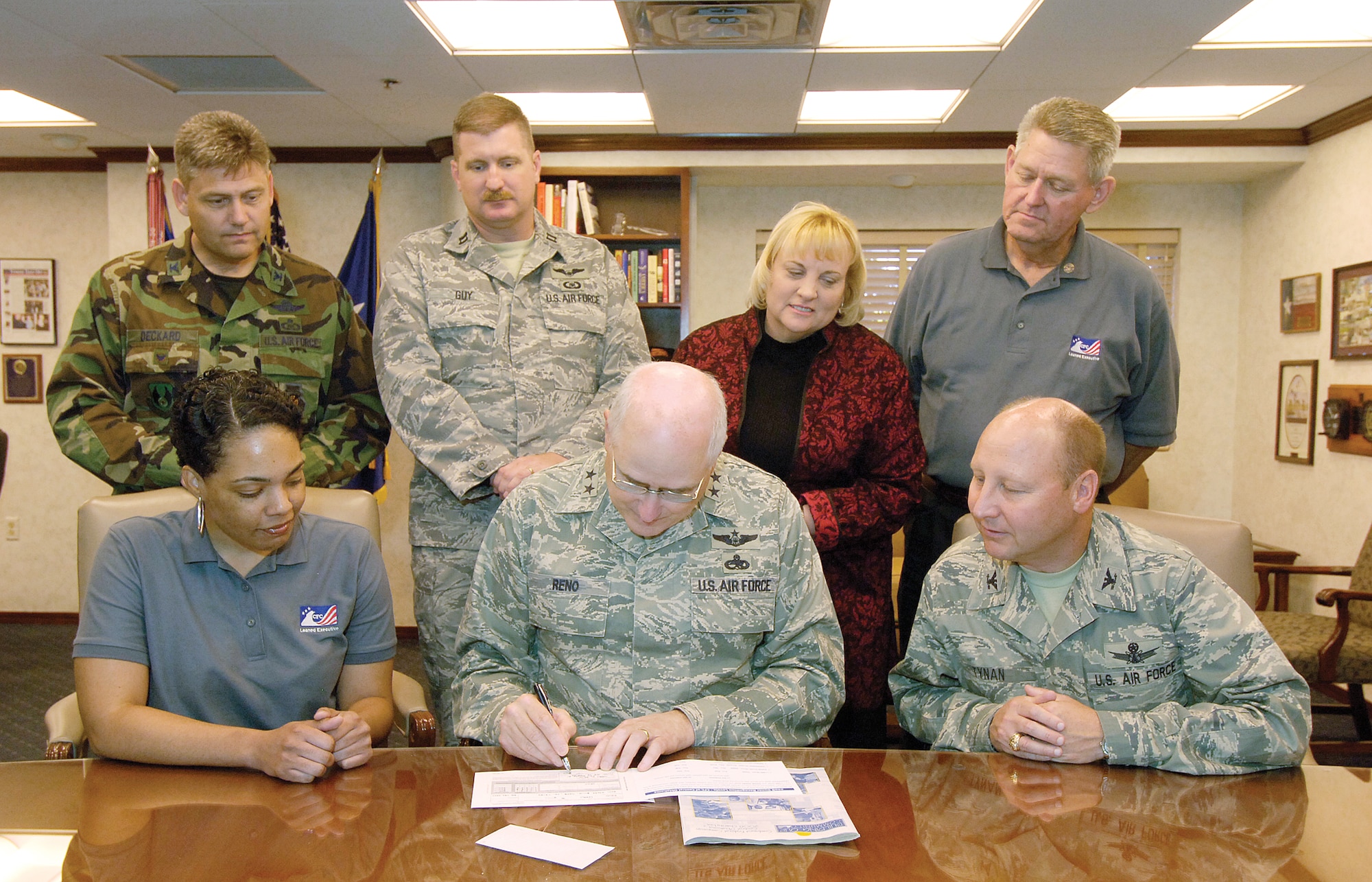 Maj. Gen. Loren Reno, Oklahoma City Air Logistics Center commander, fills out a CFC contribution card after meeting with members of Tinker’s CFC committee for this year’s drive, which runs  through Nov. 14. The commander reviewed the booklet of 2,500 organizations available for contribution designations, commenting that there’s something there for everyone. “Many have challenges,” General Reno said. “Here’s our chance to help.” Watching him sign are, seated; Ebony Morris, CFC worker, and Col. Tracy Tynan, XP. Standing, are, from left; Col. Andy Decker, Plans and Programs; Capt. Dave Guy, CFC worker; Patti Ford, chief of staff; and Larry Marlatt, CFC worker. Team Tinker’s goal is $1.65 million.(Air Force photo/Margo Wright)
